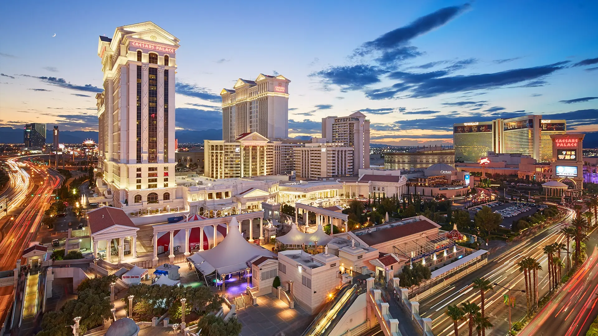 Large white biulding with text in red saying "CAESARS PALACE" with a very wide format taking up a lot of space.