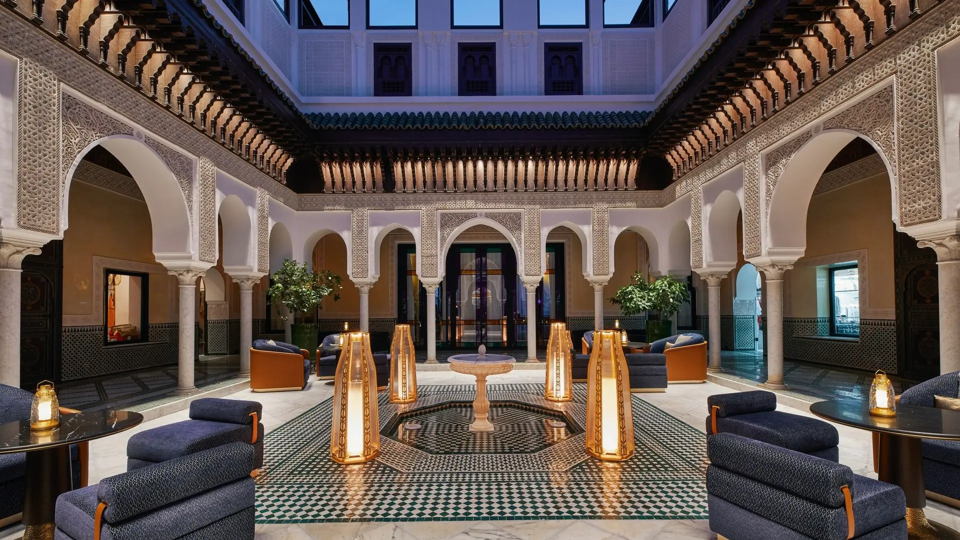 Spacious lounge with blue seats, marble floor and lamps that give tender lighting
