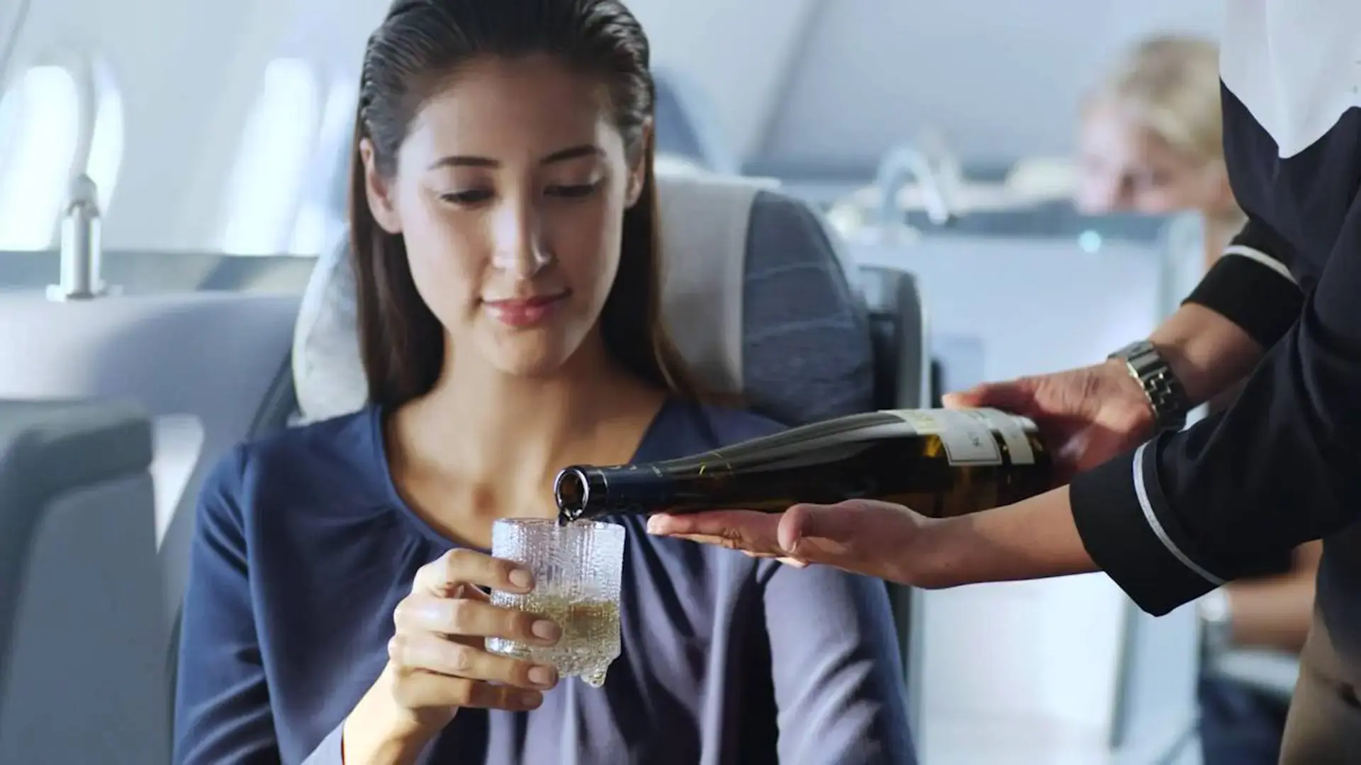 A woman getting alkohol to drink at a airplane