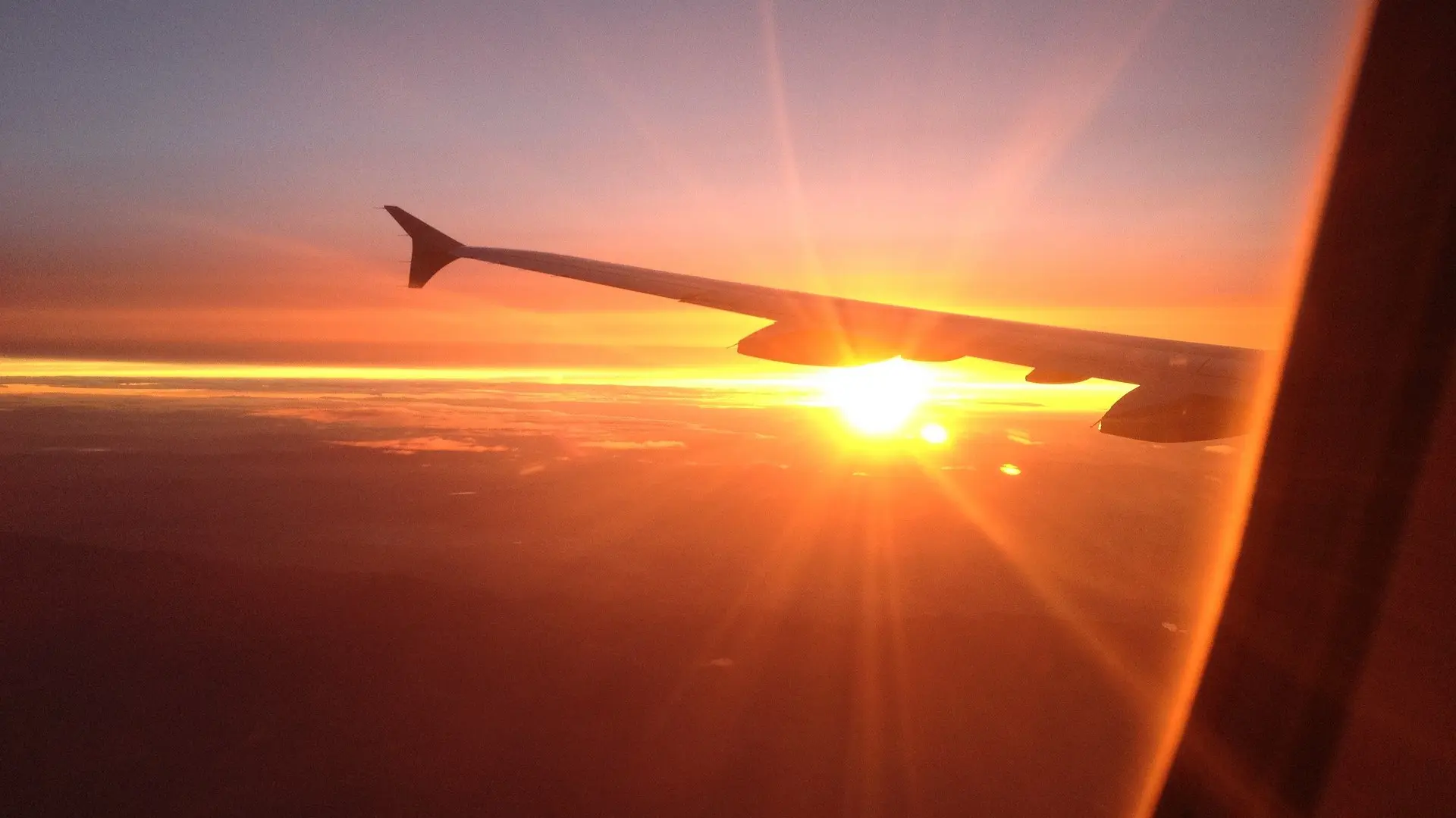 outside view from a window plane with the sun shining over a plane