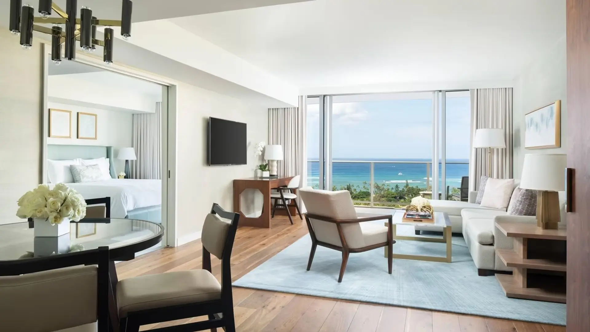 Hotel room with sofa, bedroom and window to the ocean at The Ritz-Carlton Residences, Waikki Beach.