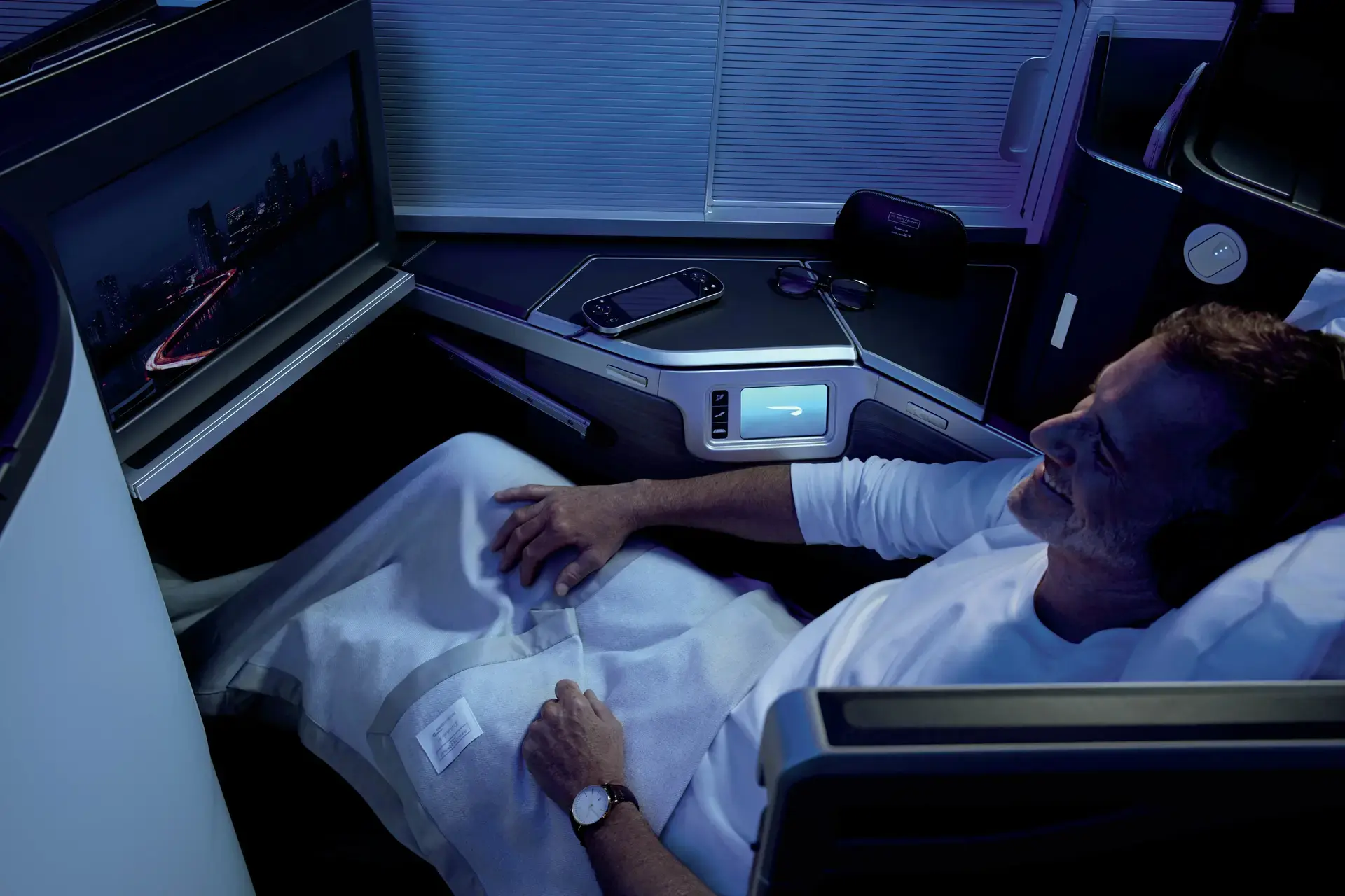 a man watching tv in in the british airways new club suite