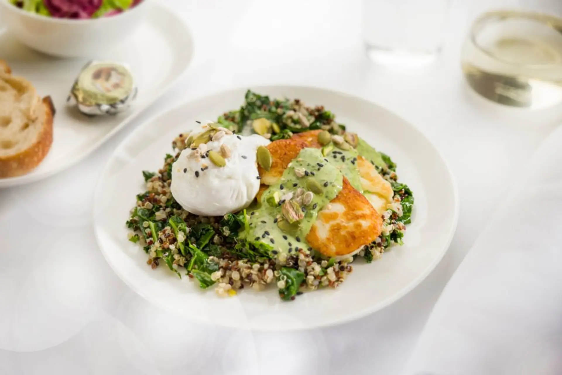 Poached-eggs-with-kale-quinoa-grilled-haloumi-pistachios-seeds-and-herbed-tahini-dressing-Business-breakfast-menu-ex-PERL-1000x667.jpg