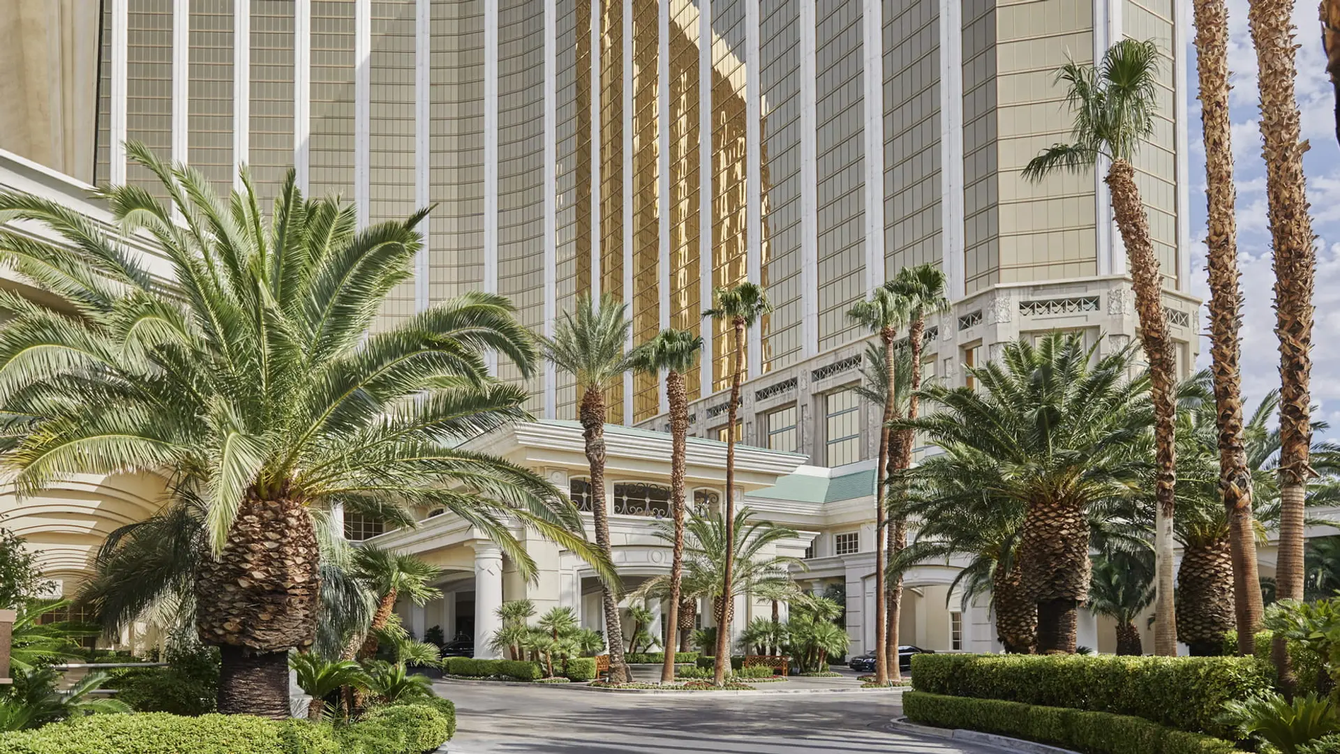 Palm trees, large white building, golden strips The Four Seasons Las Vegas.