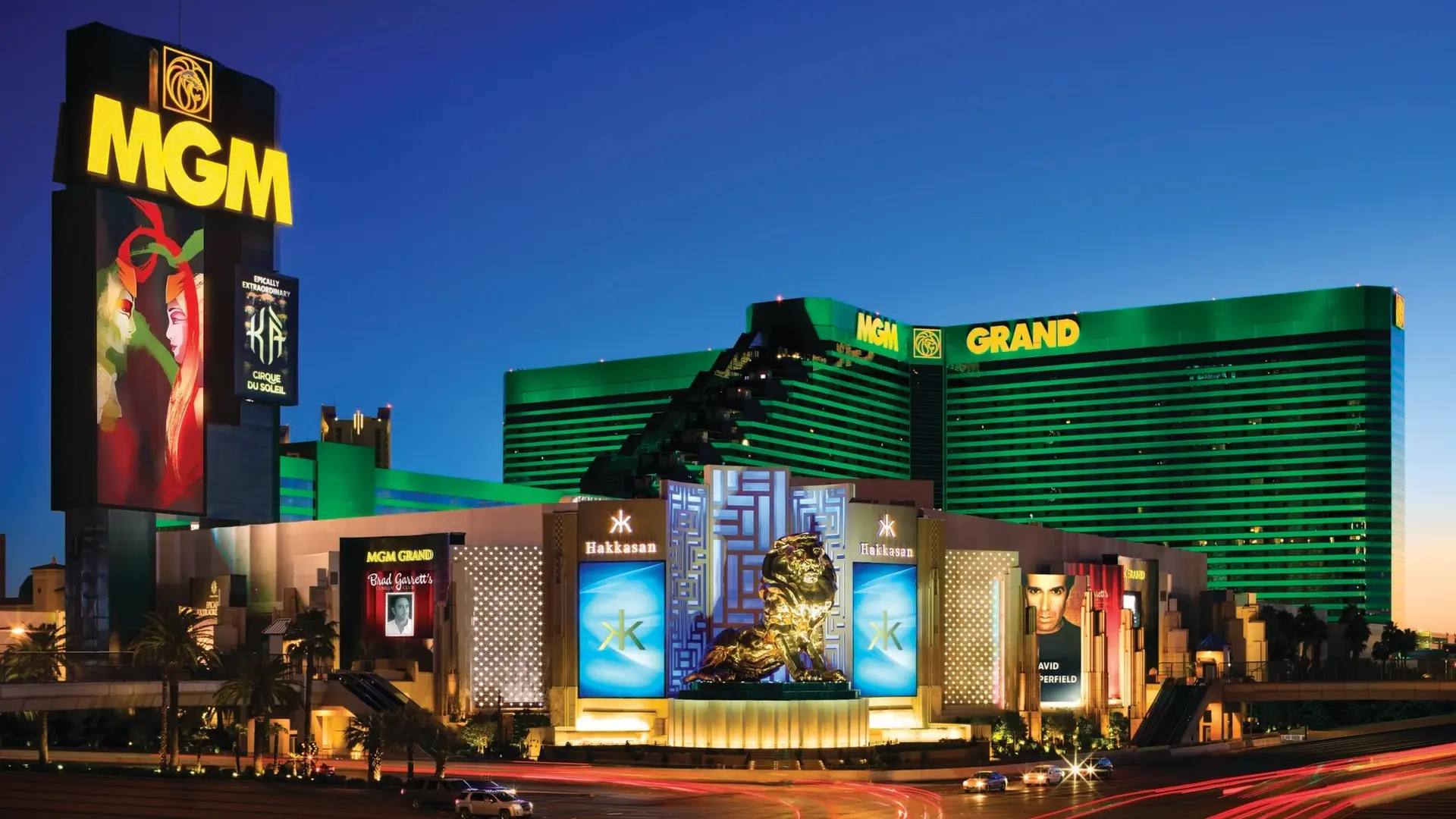 Golden lion statue, advertisements saying: Hakkasan and MGM GRAND, behind front green building saying: MGM GRAND in yellow font.