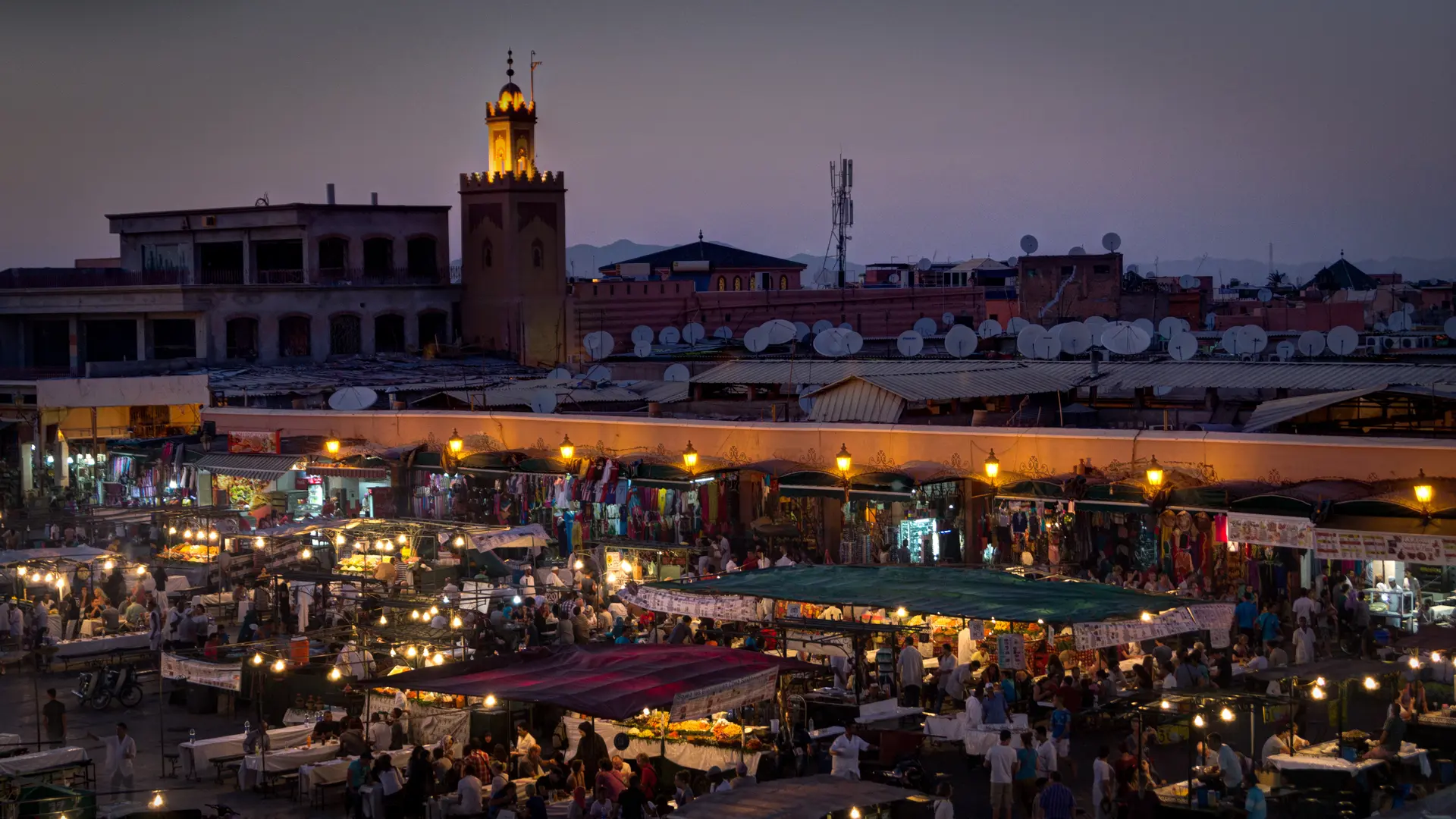 moroccan market and seat tables with many people sitting. 
