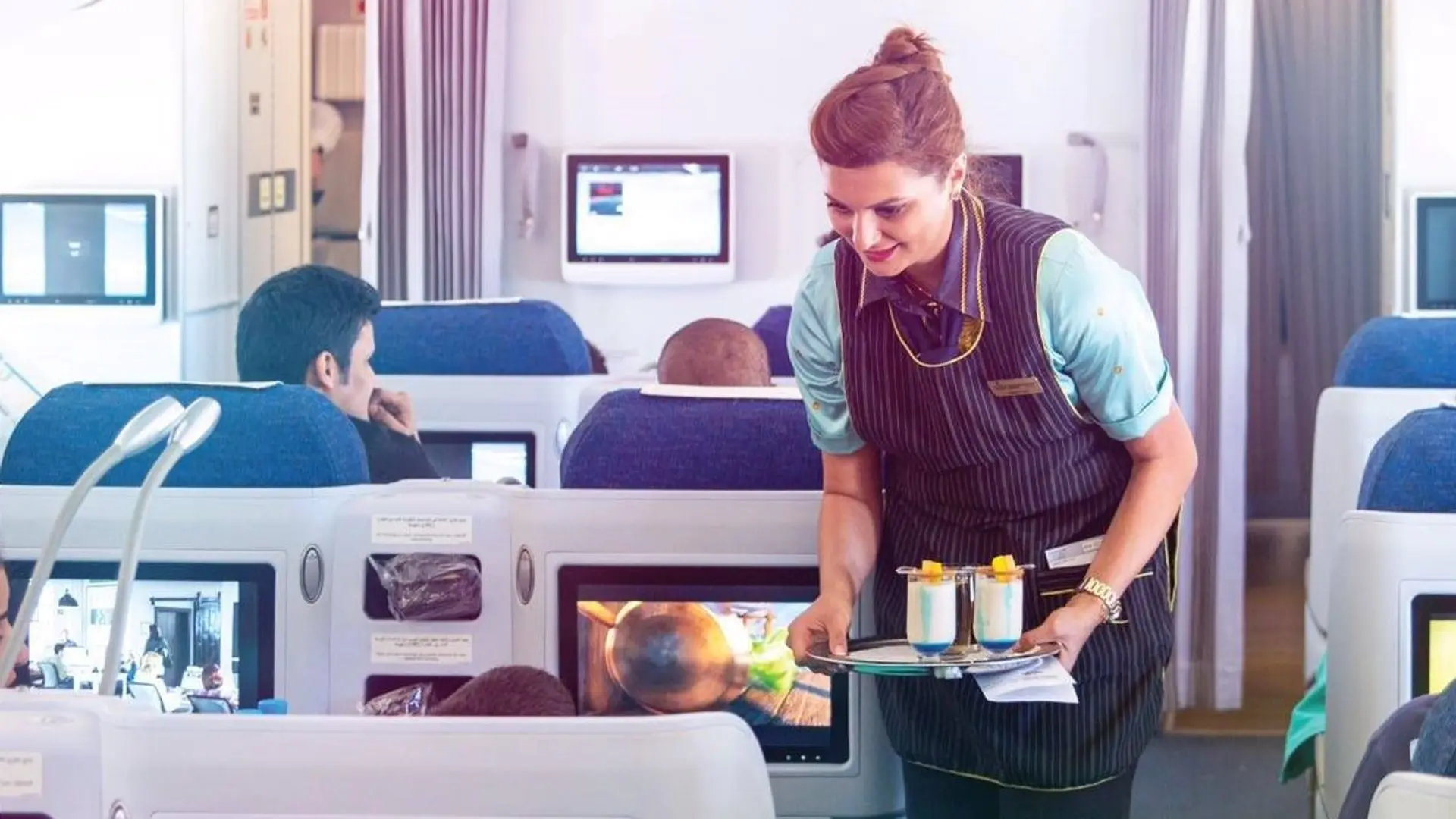 air hostess serving non alcoholic drinks in Kuwait Airways Business Class