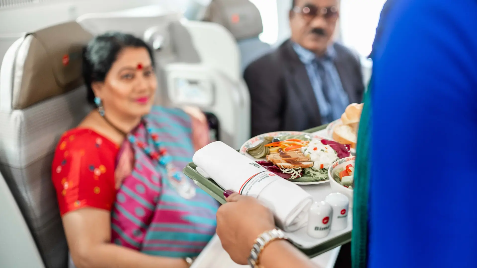 a couple being served food in the biman bangladesh airlines business class