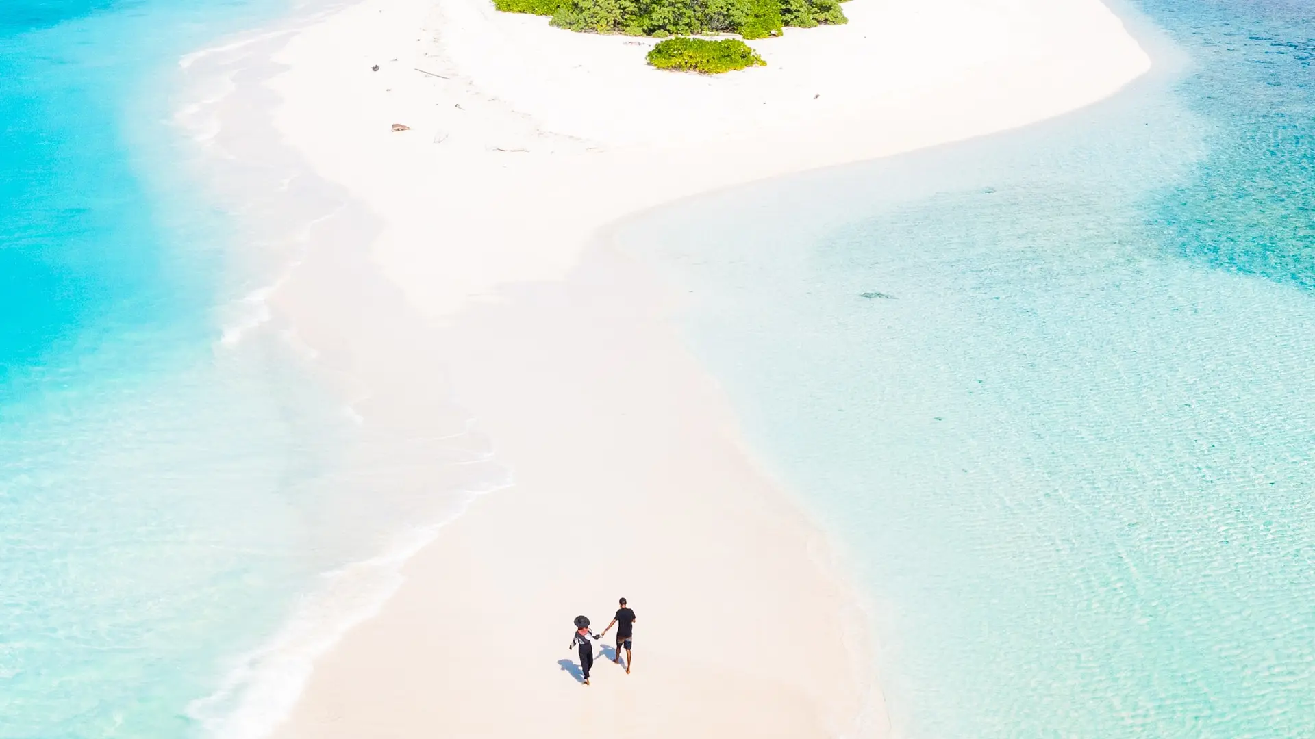 a couple walking on a beach in maldives