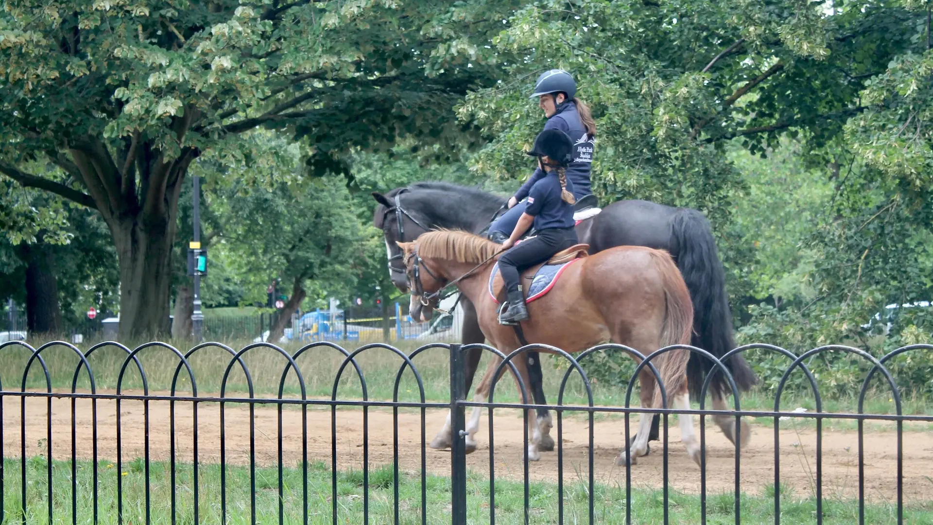 an instructor teaching a student how to ride a horse at Hyde Park Stables 