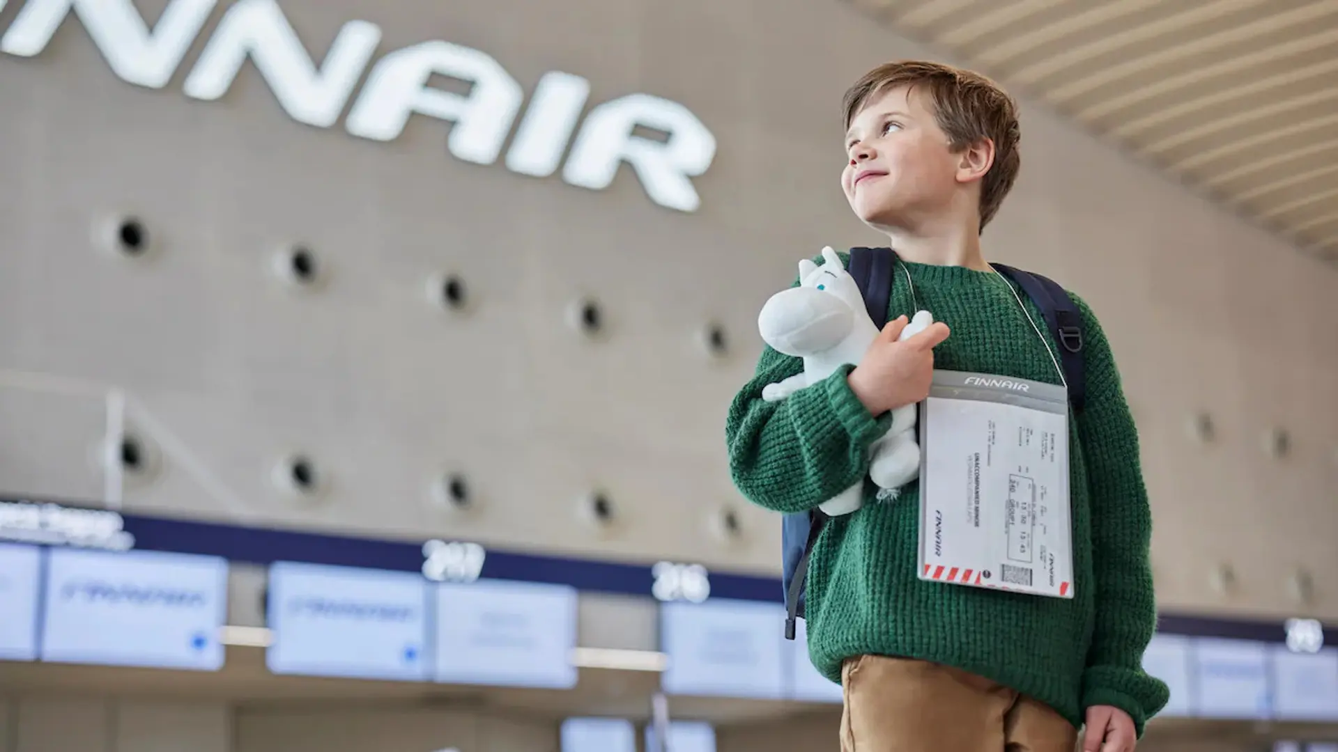 a young boy at an airport with his toy