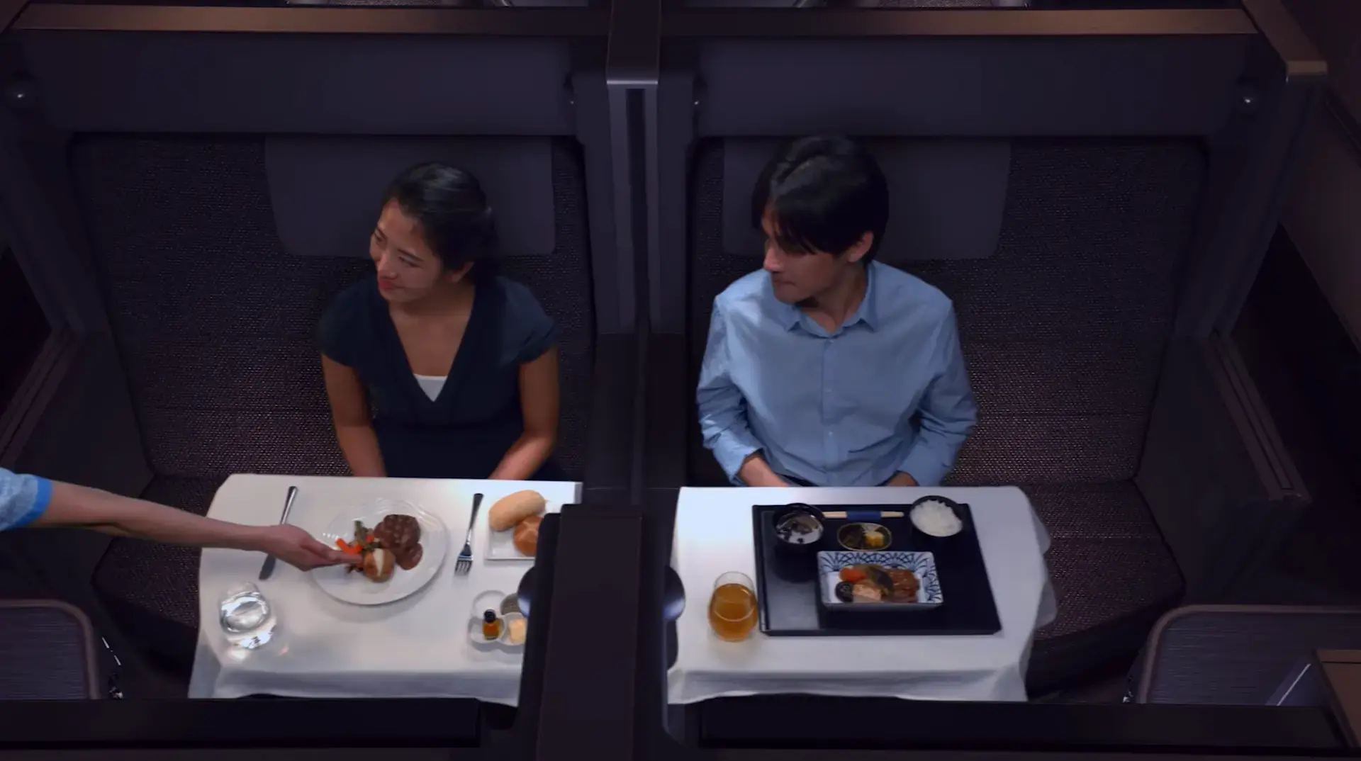 a couple being served food in ANA All Nippon Airways