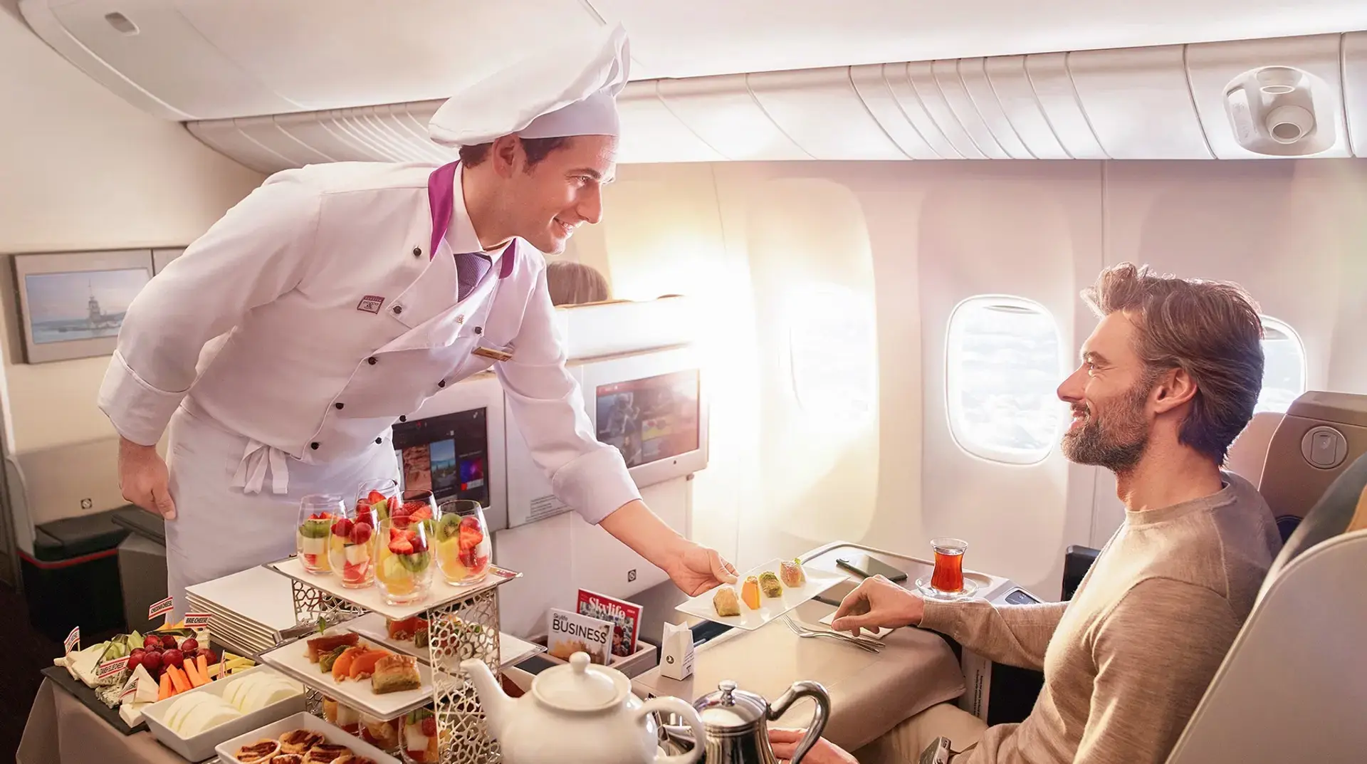 a passenger being served food at Turkish Airlines Business Class