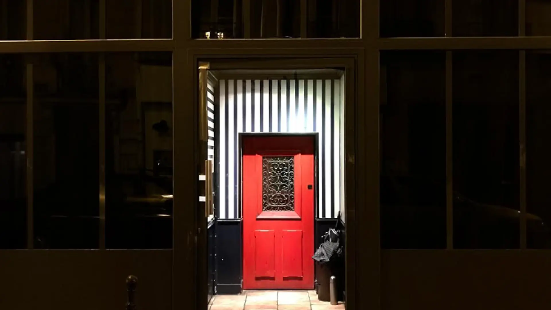 Black walls and a small way in to a small little red door.