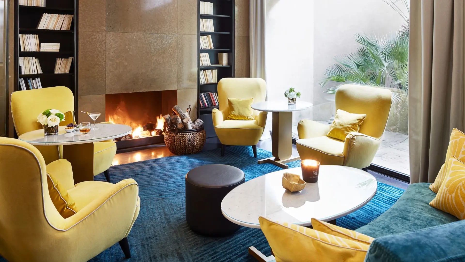 Relaxing area with yellow furniture and a fireplace at hotel montalembert paris