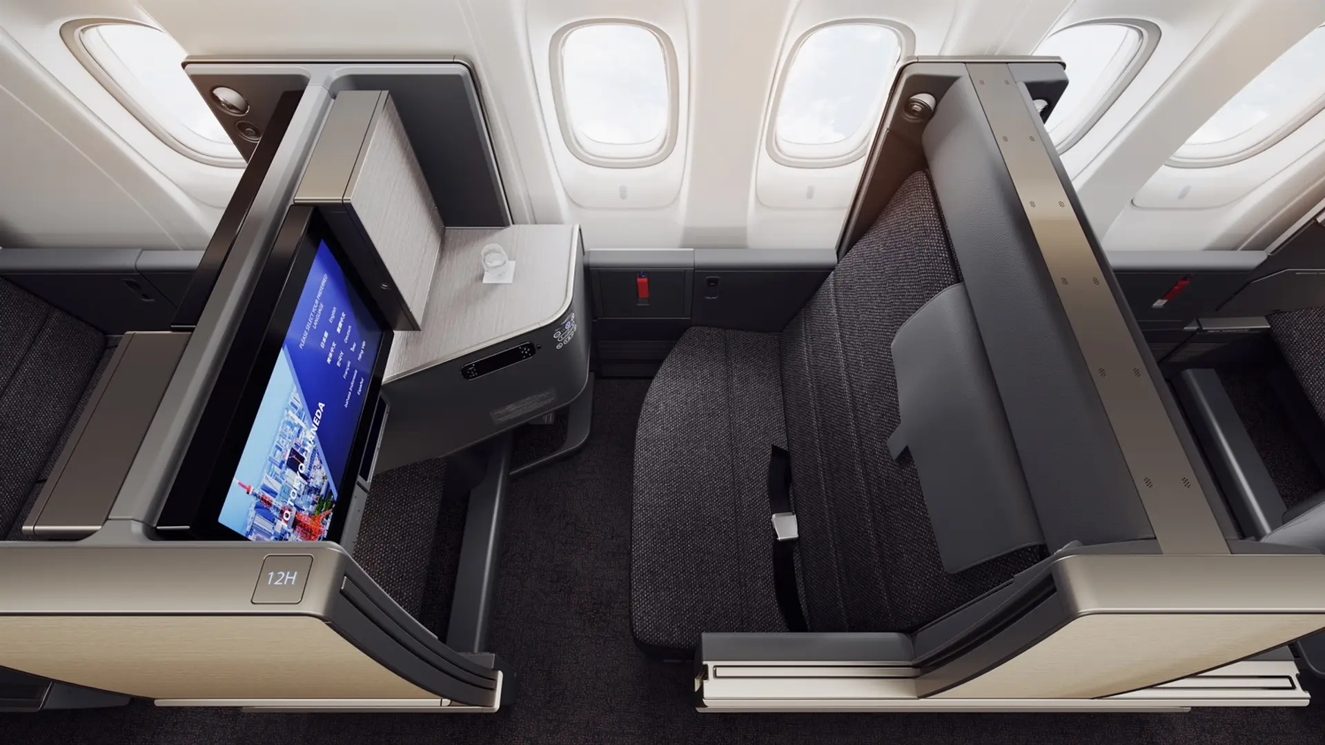 Luxurious businessclass seat with a black and gold finish with a smart screen facing the seat.