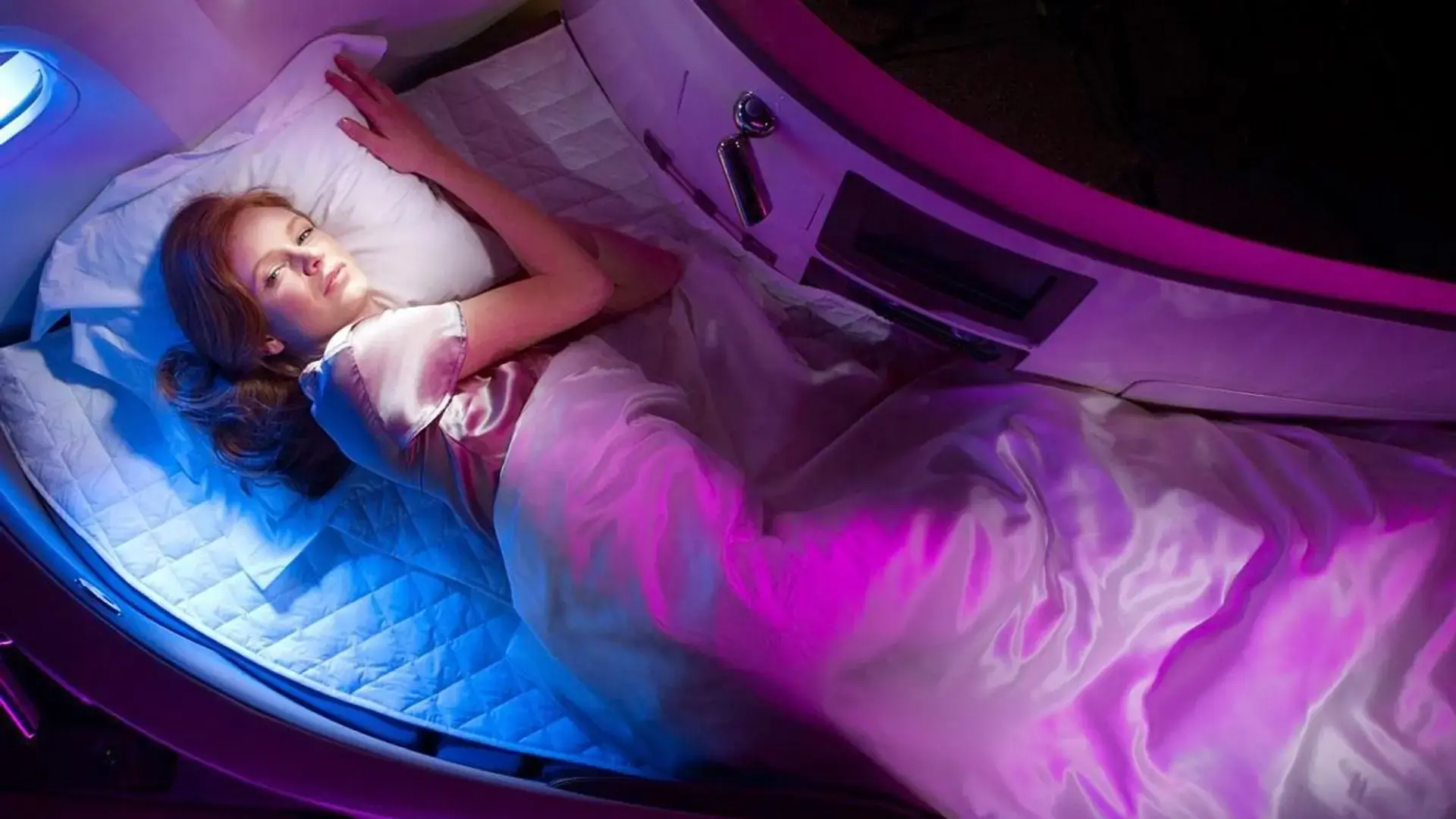 a woman sleeping in the lie flat bed of Virgin Atlantic