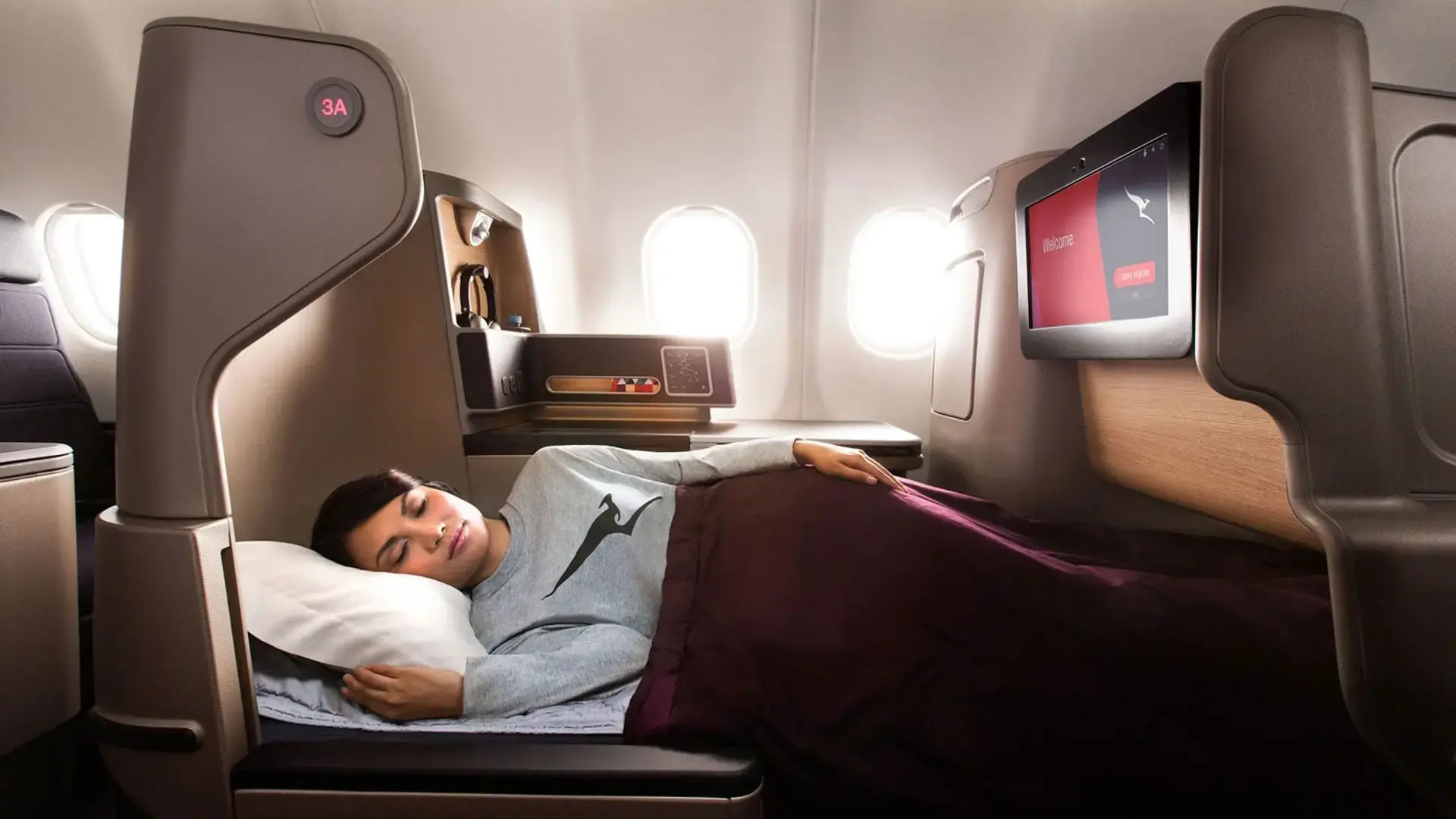 woman sleeping in the Qantas Business Class seat that lies flat