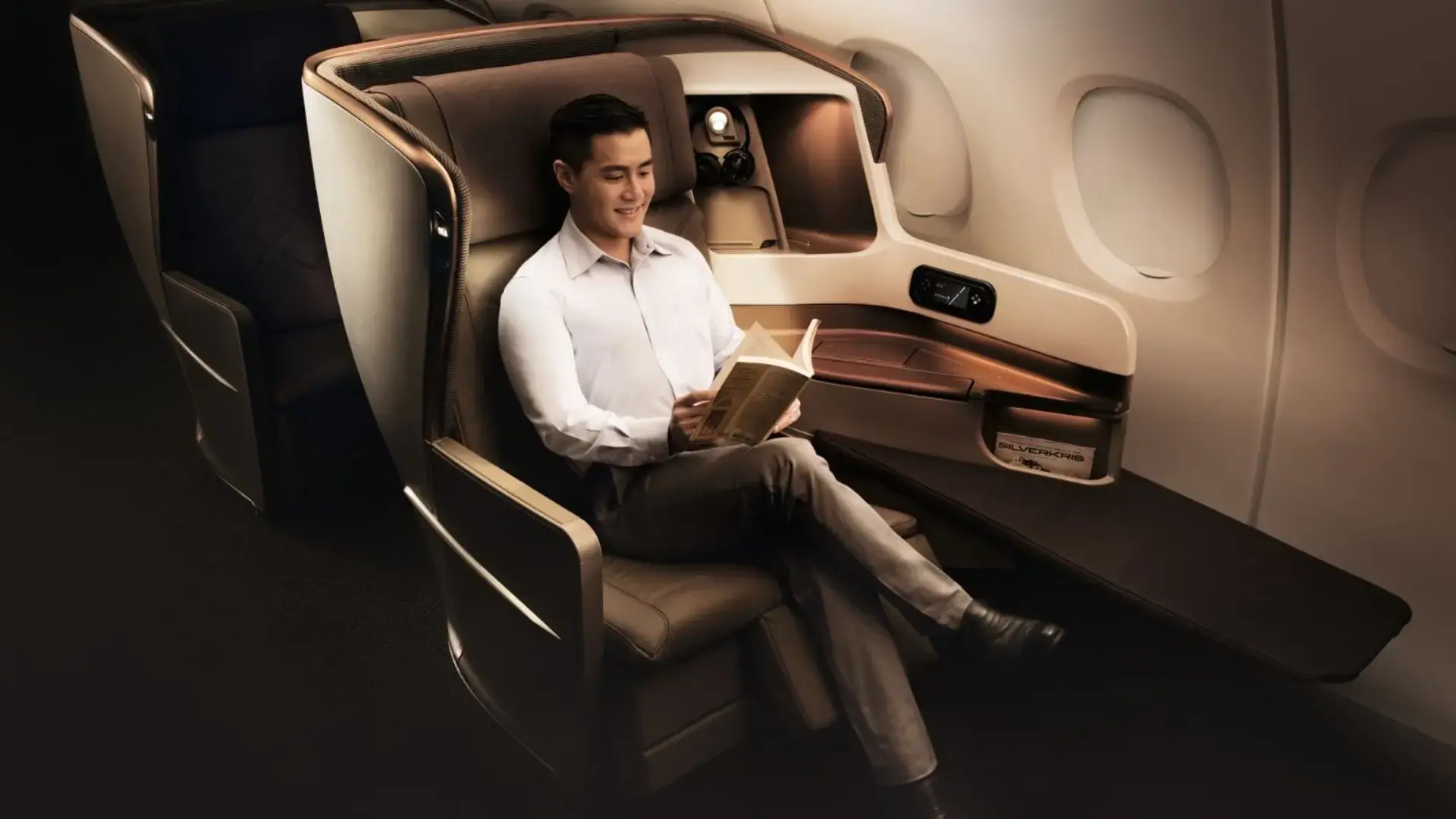 a man reading a book in the Singapore Airlines business class