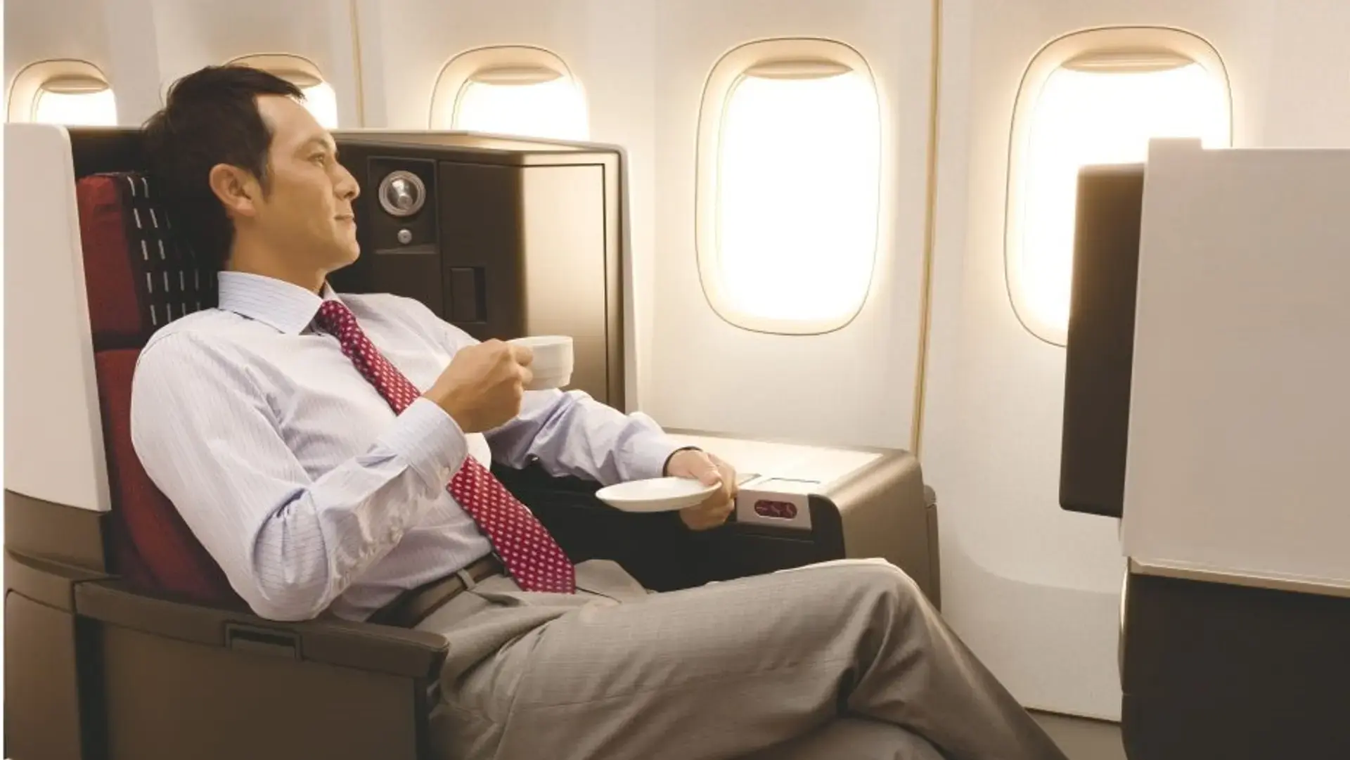 a man enjoying a cup of tea in the Japan Airlines business class
