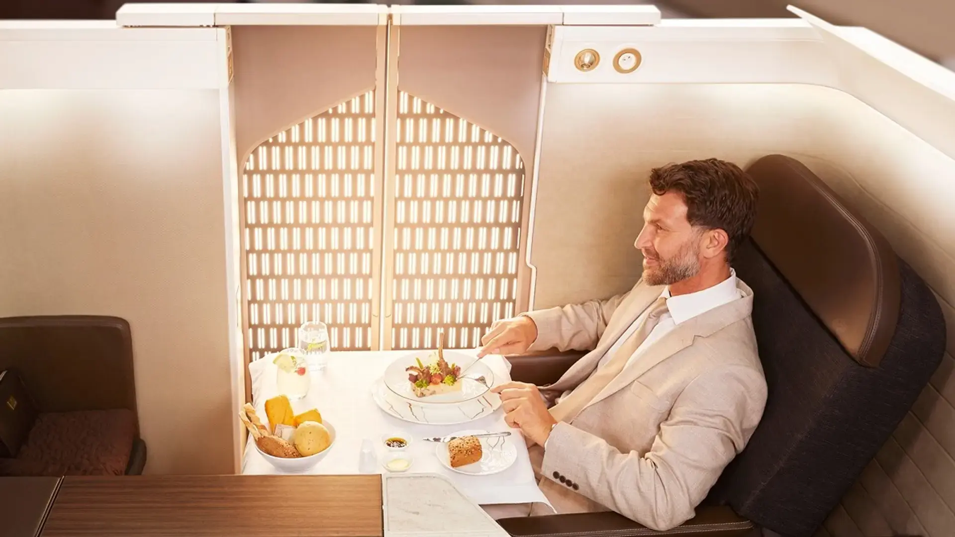 a man eating lunch in oman air first class