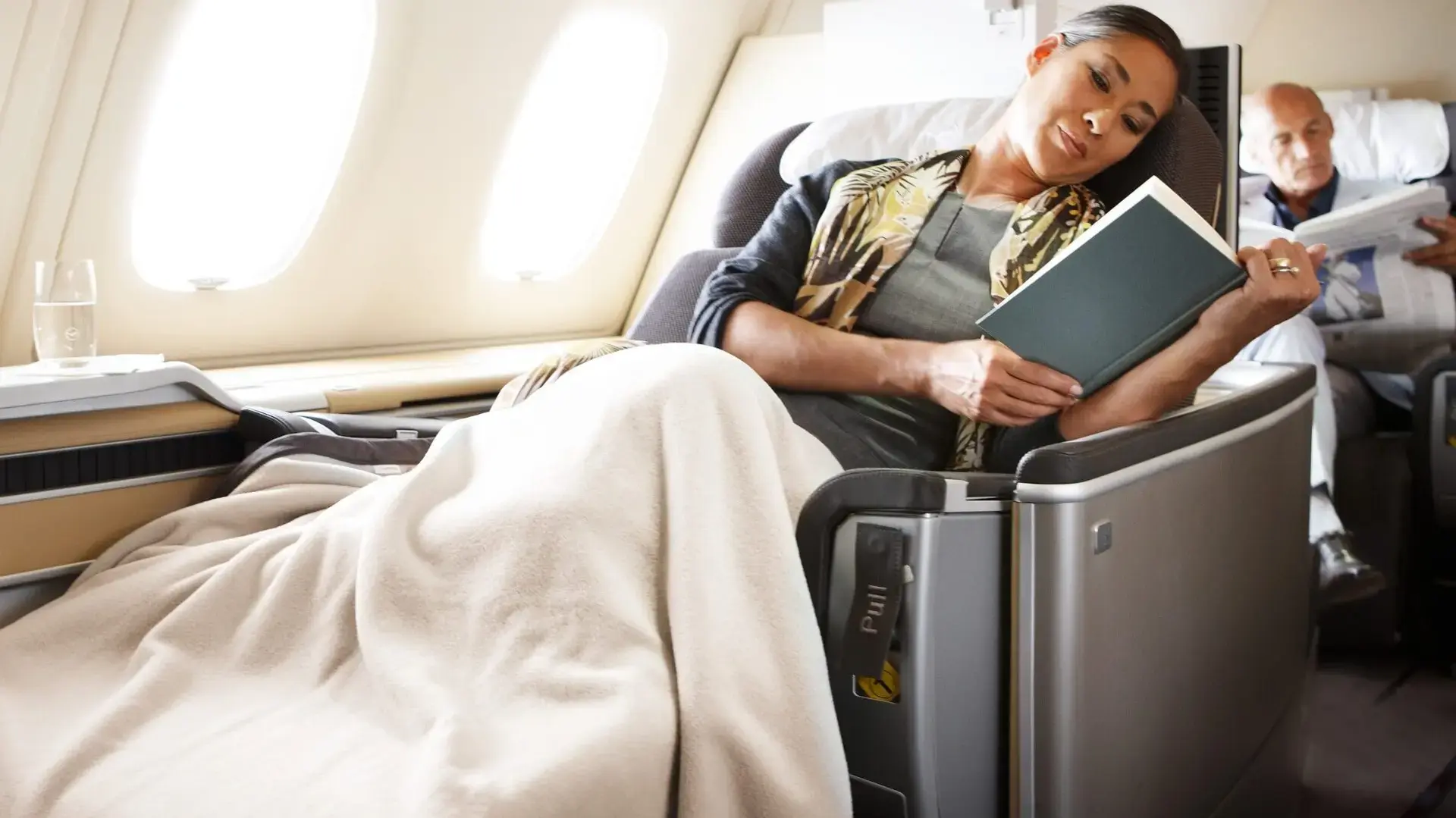 a woman reading a book in Lufthansa first class
