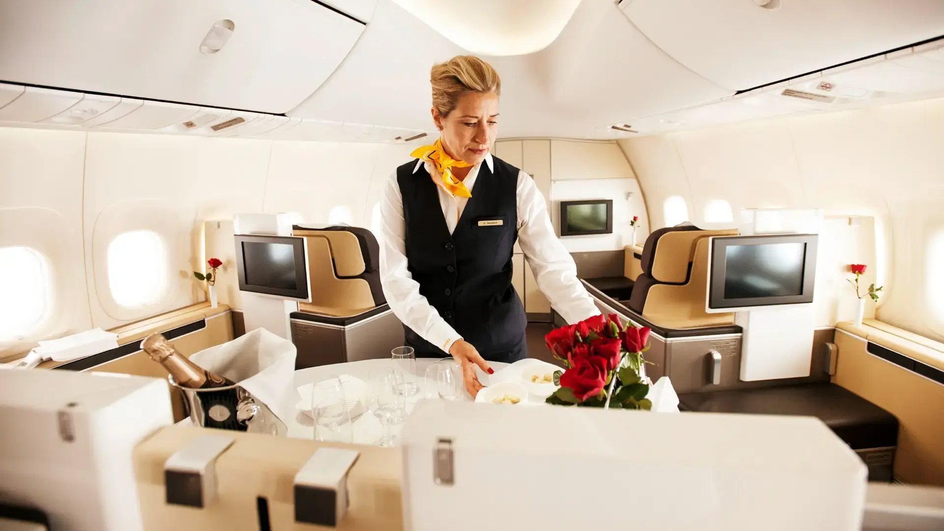 an air hostess setting up a table in lufthansa first class
