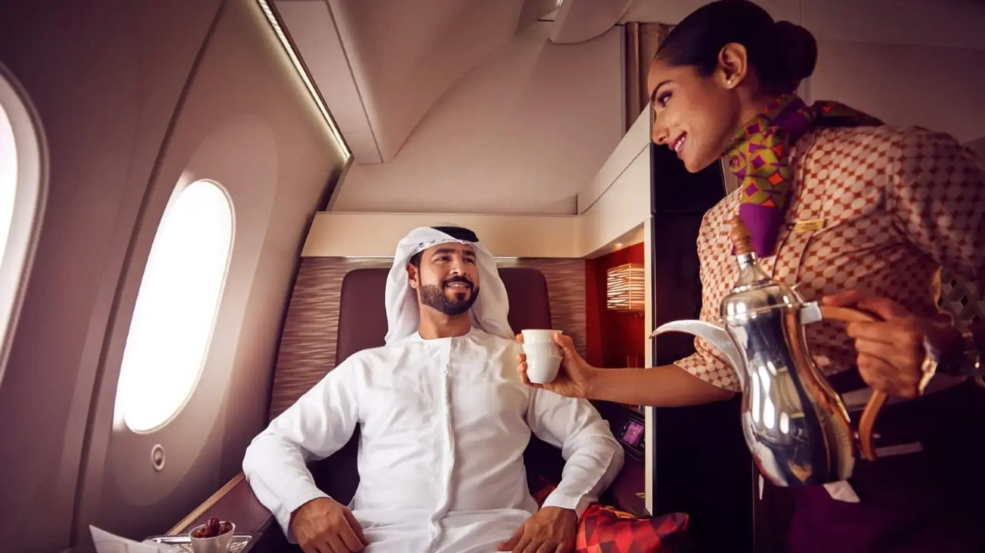 airhostess serving tea to a man in etihad first class review