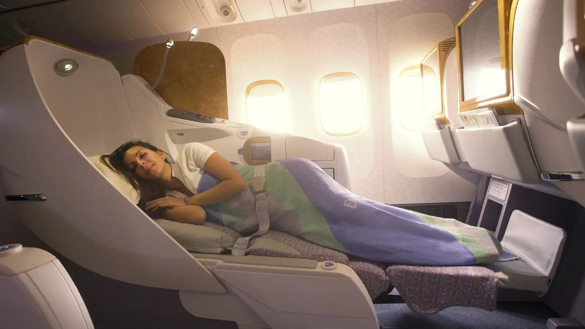 an indian woman sleelping in the emirates airbus 380 seat