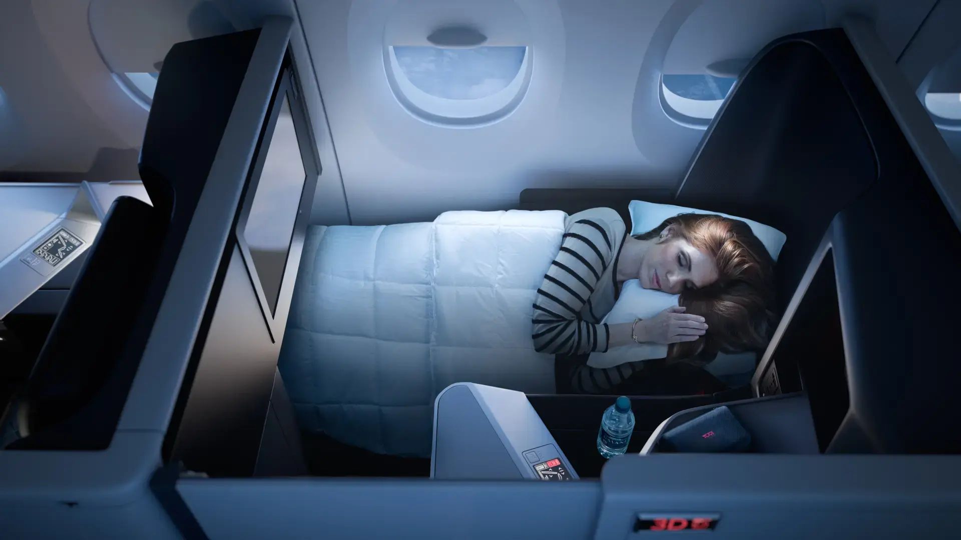 a woman sleeping in her Delta One Suite - Airbus A350