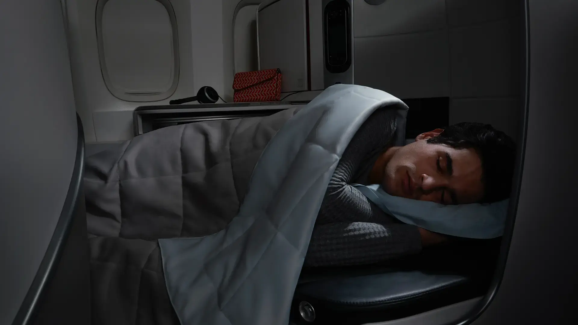 a man sleeping in his air france boeing 77-300er seat