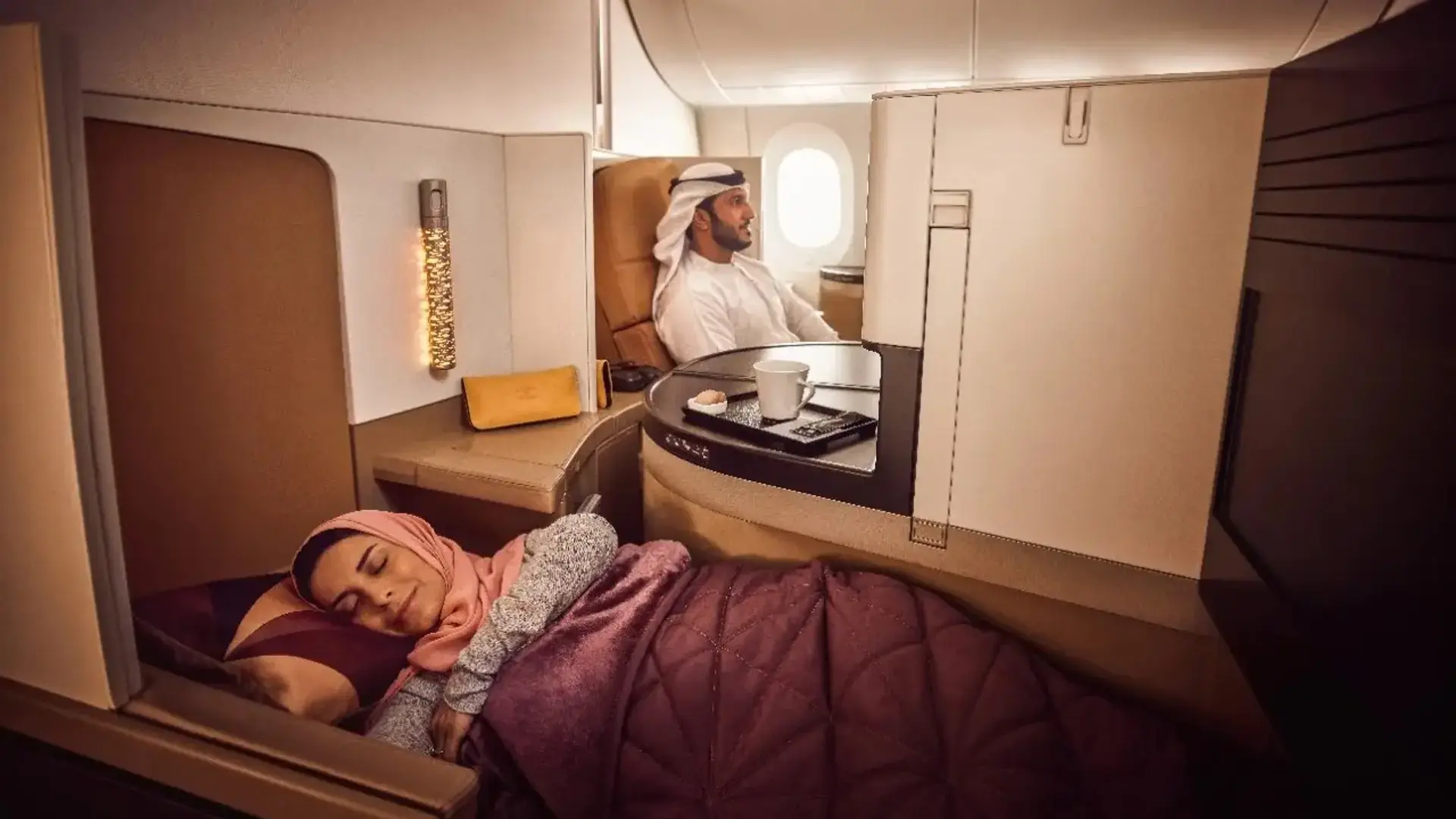 a couple resting in their Etihad Airbus A350-1000 Business Suites