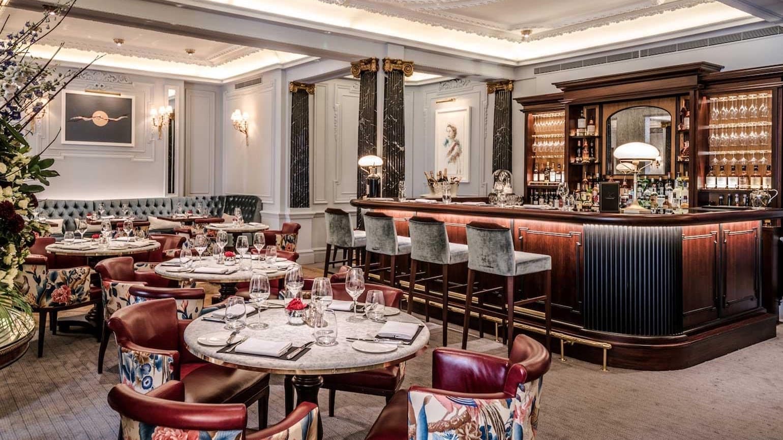 A bar and resurant at the stafford london with round tables.
