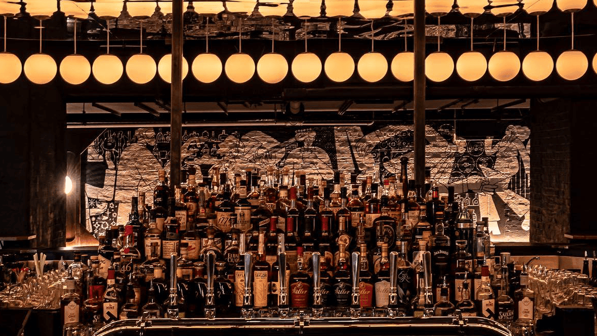 A lot of different drinking beverages at Experimental Cocktail Club with black and golden backround.