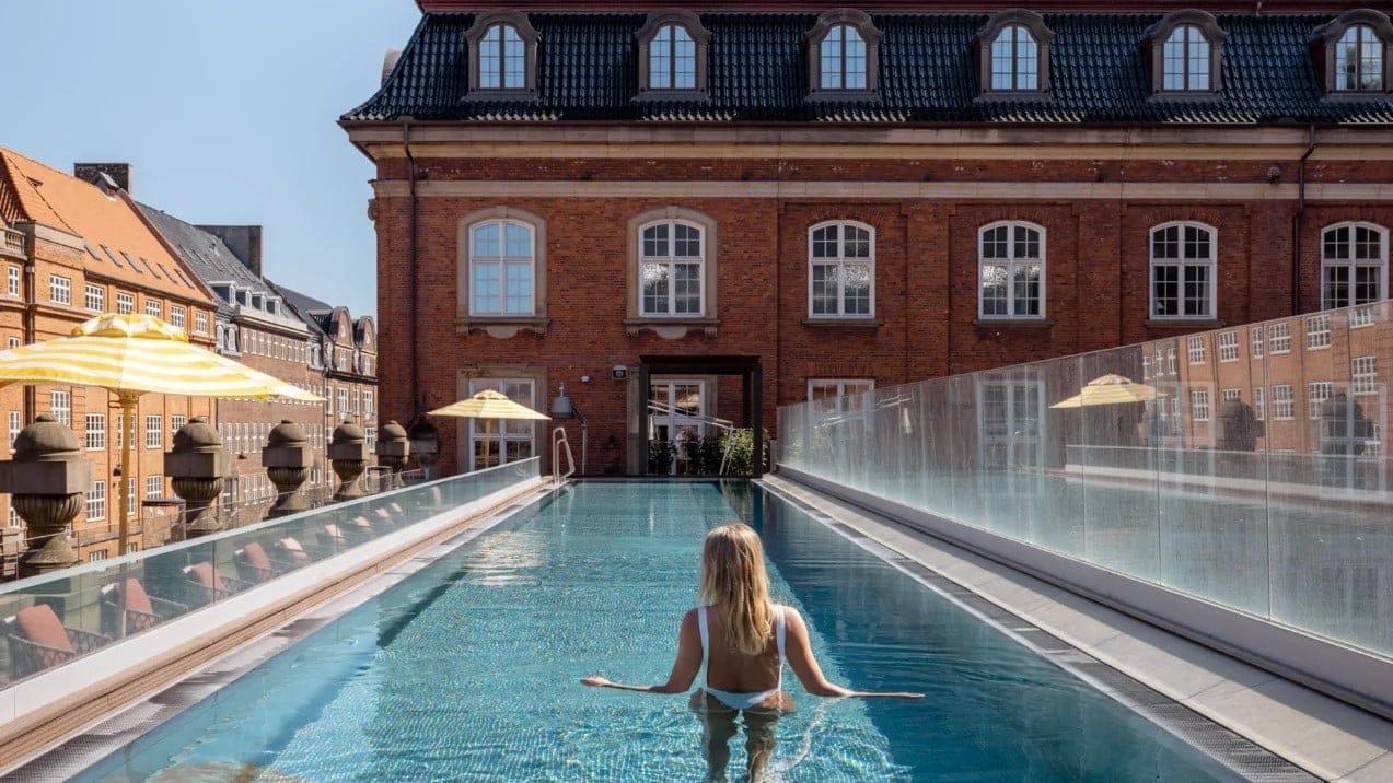 Woman standing in a outdoor swimming pool at villa copenhagen hotel