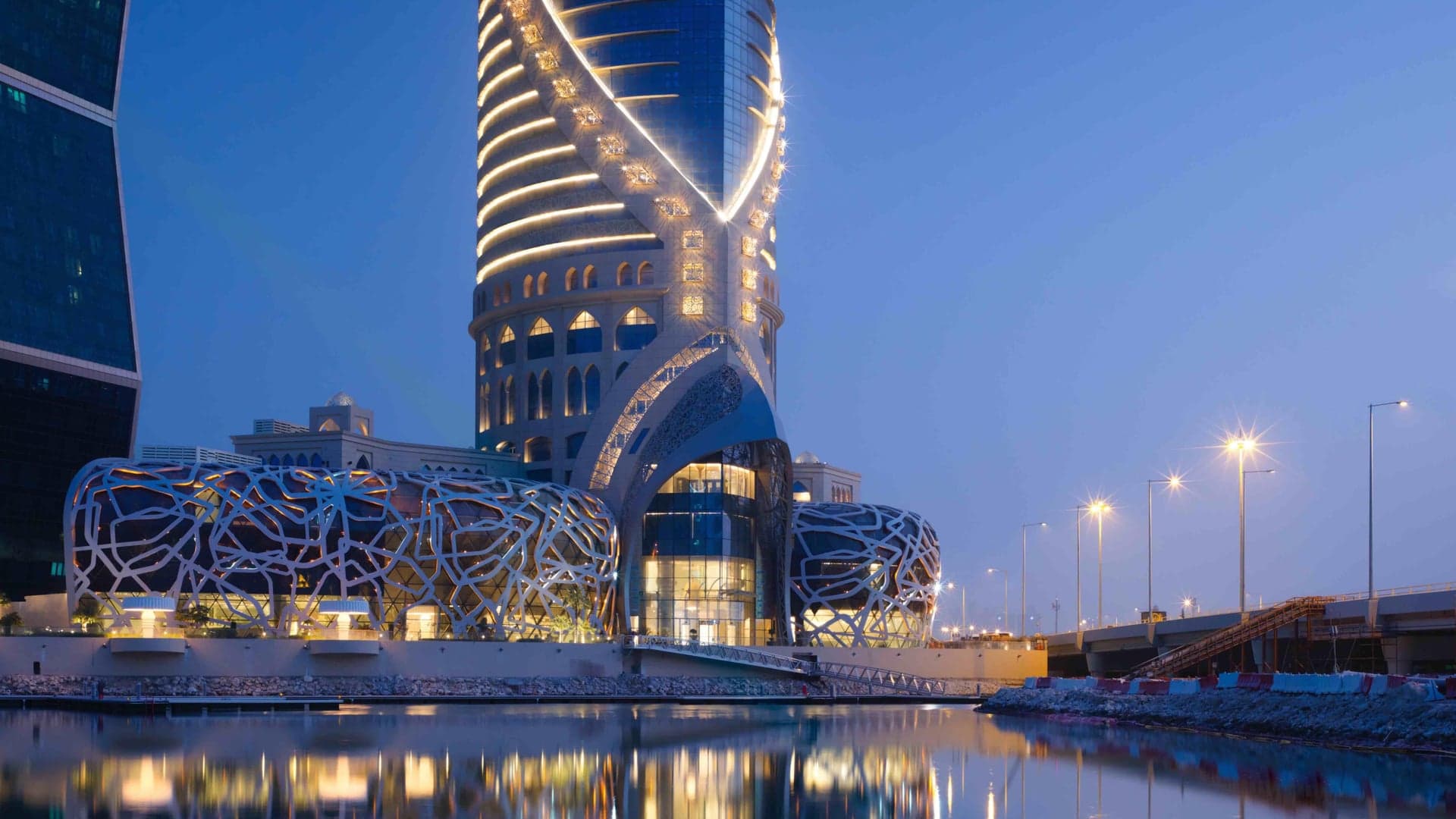 Outside view of The Mondrian Doha, Modern design with a large upward spiral with beautiful lights and windows.