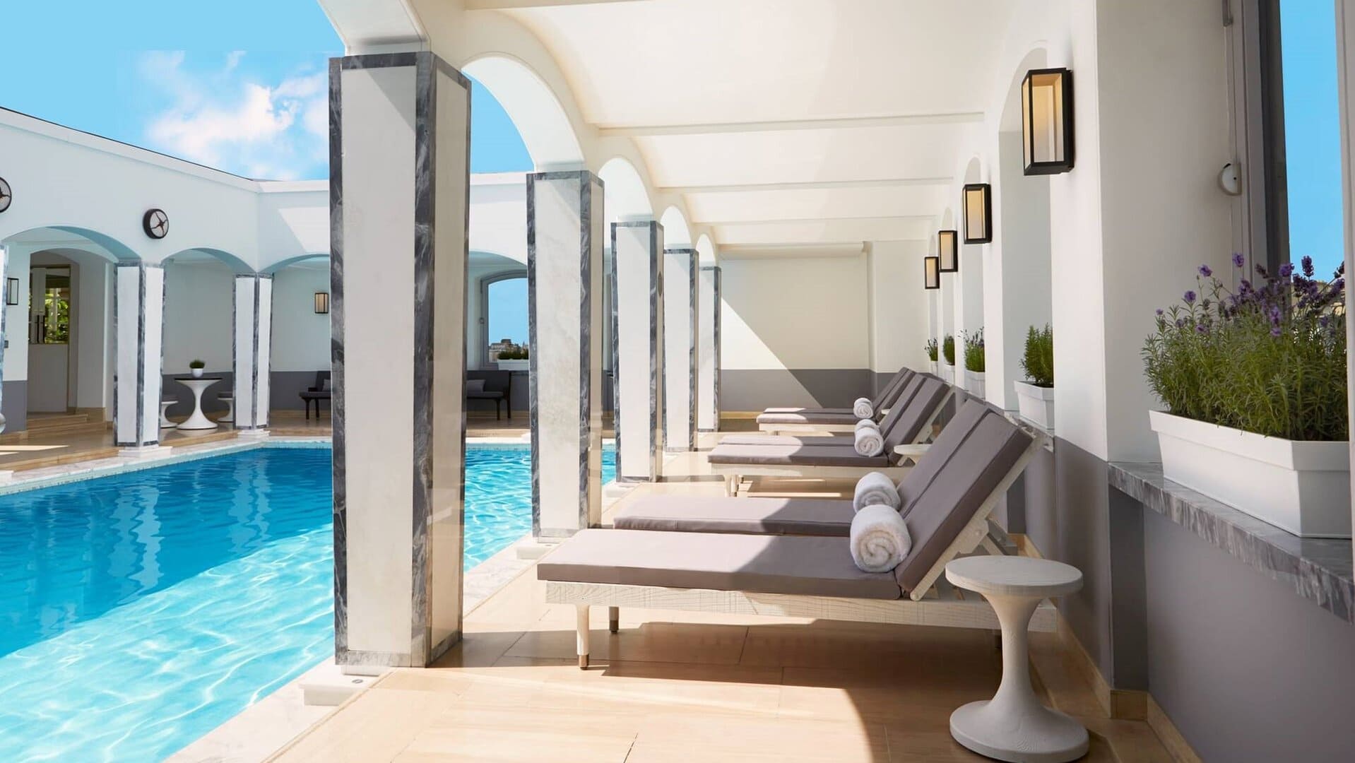 Outside pool area with sunbeds and white columns at the berkley london