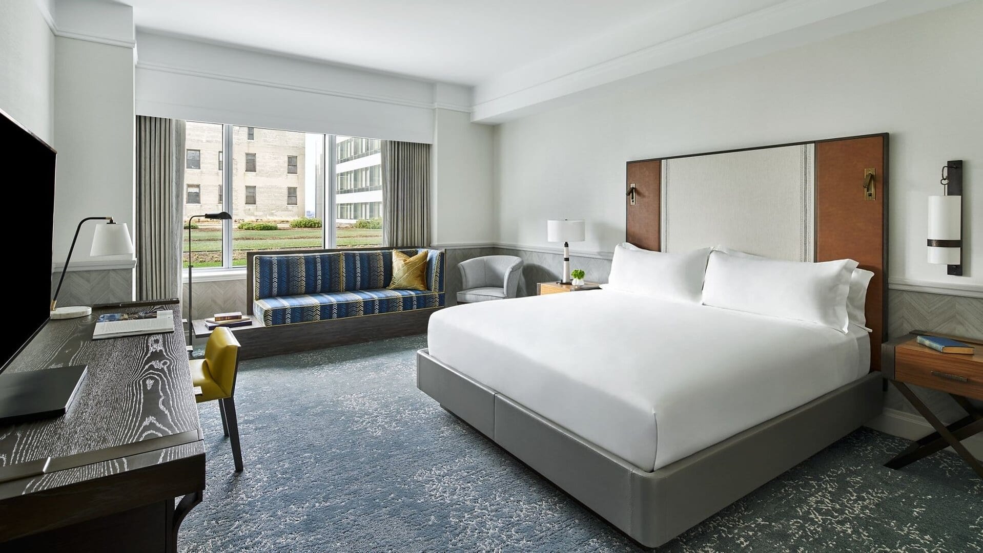 hotel suite with a king sized bed, a tv infront.