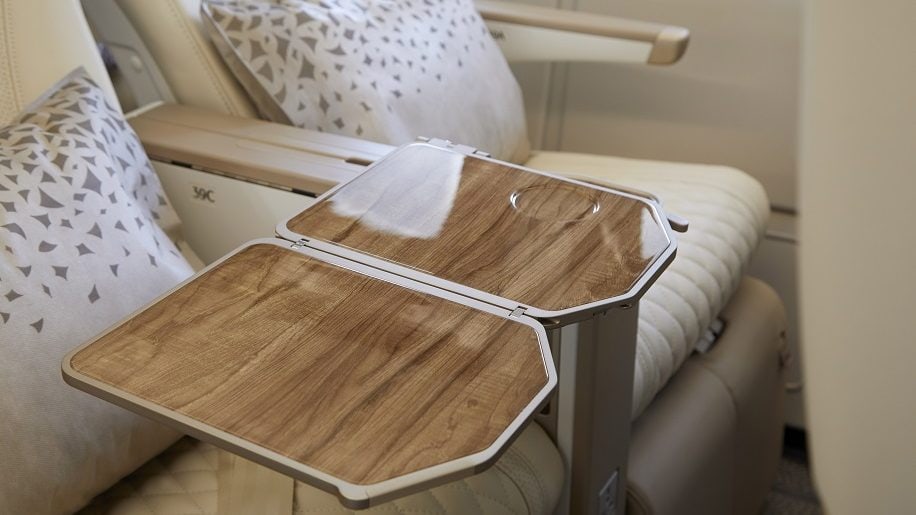 White leather seats with pattern pillows and shiny wood desk
