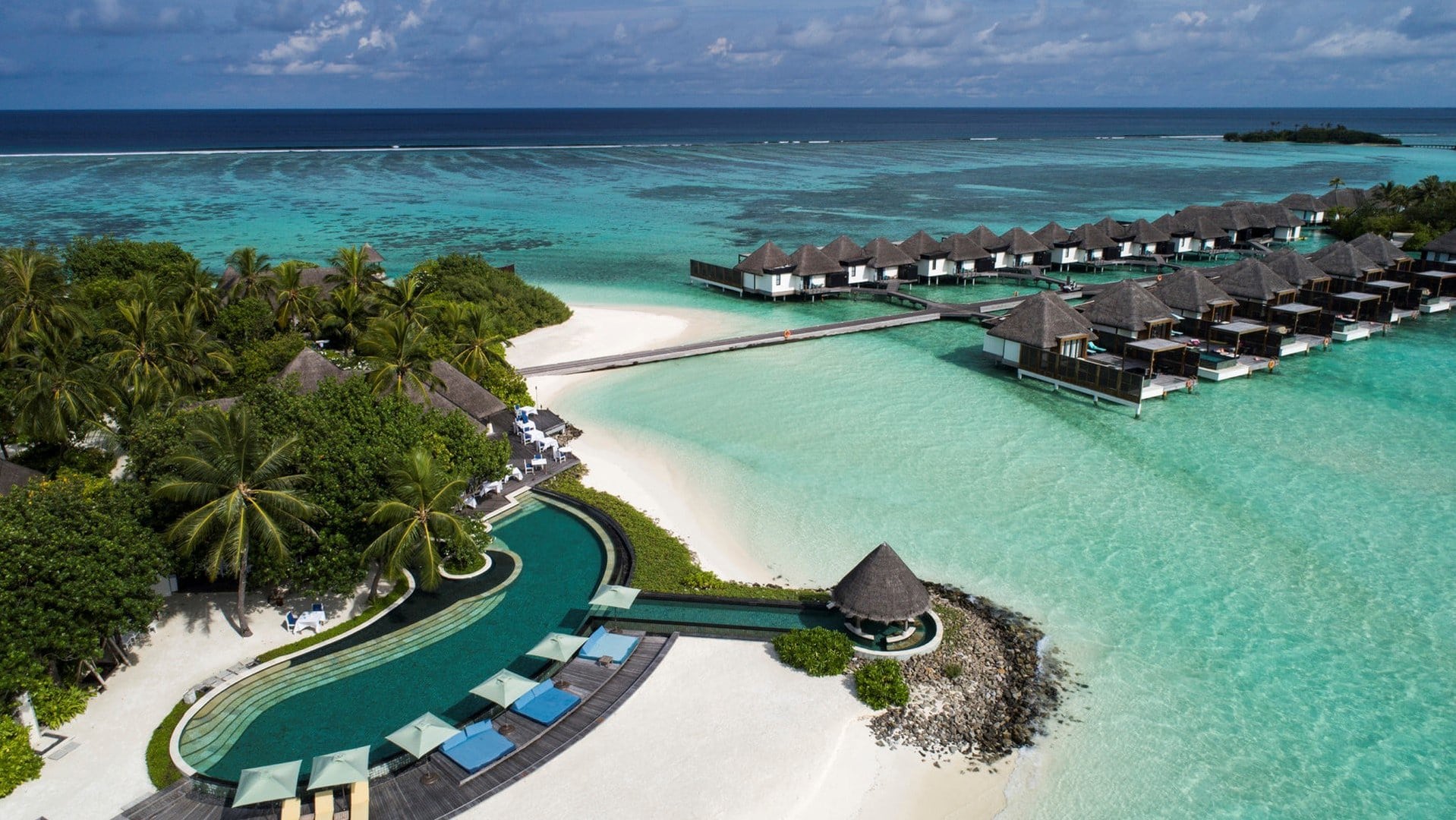 Four Seasons Resort Maldives at Kuda Huraa with pool, beach, palmtrees and extension cabins out on the water.