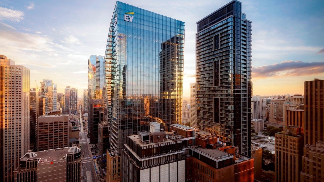 Outside of the st regis toronto hotel made of glass with toronto city in the background.