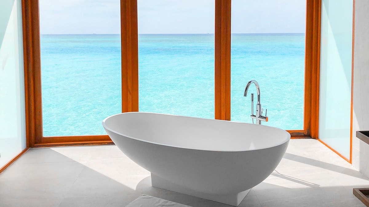 White bathtub with view to the water at Anantara Dhigu Maldives Resort.
