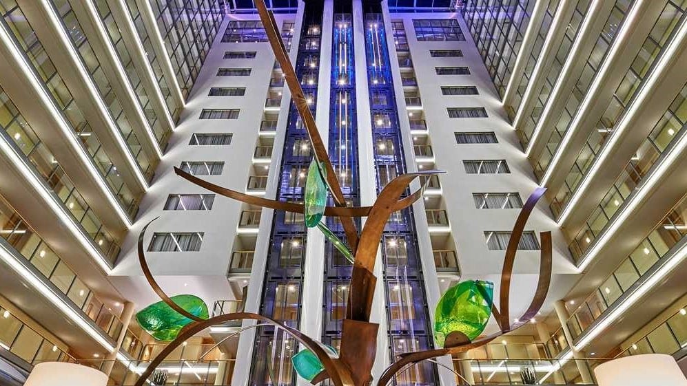 Bronse and emerald green statue in between a large building