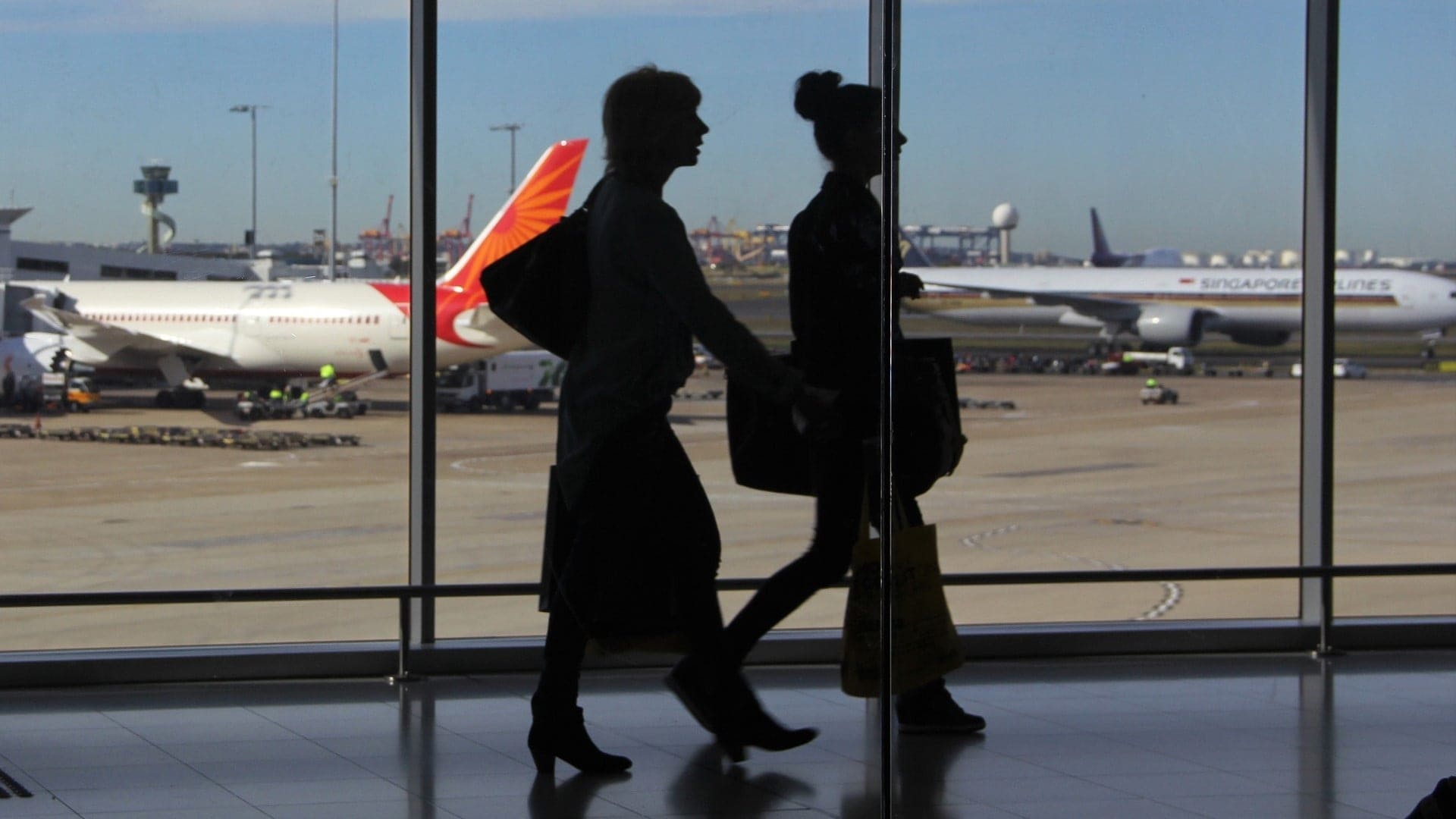 two women walking in an airport