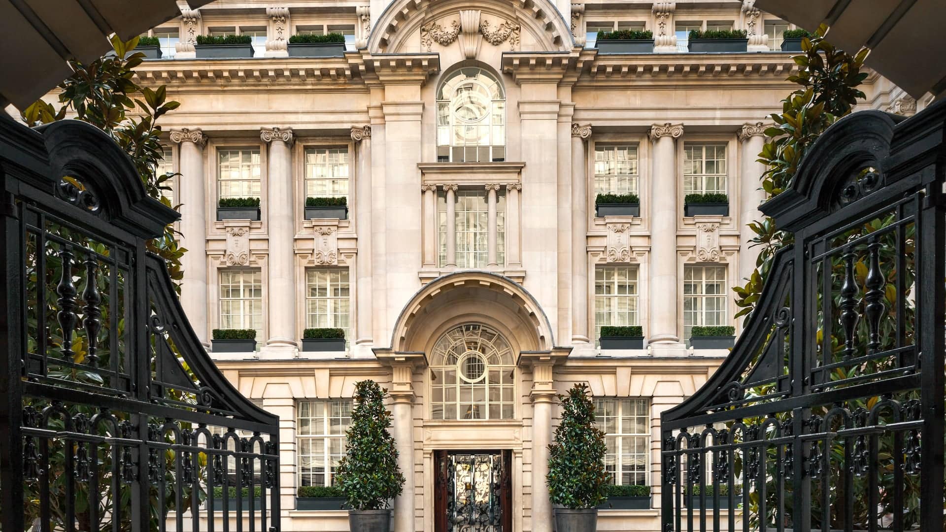 Front entrance of Rosewood london hotel with a black gate in the foreground.