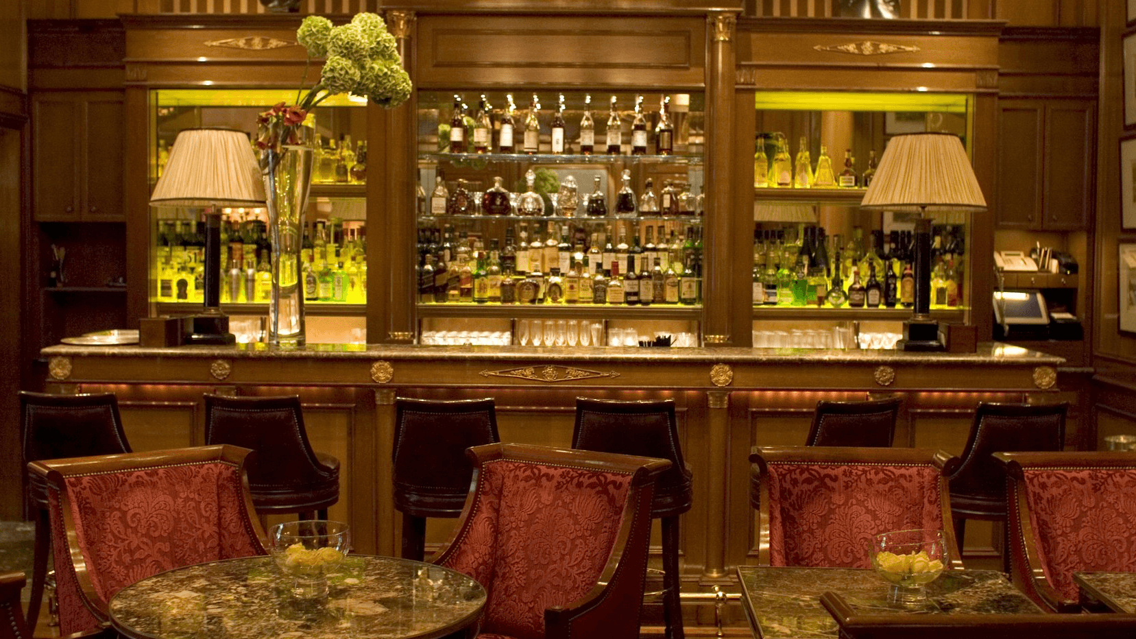 Le Bar, red chairs, marble tables and cocktail bar.