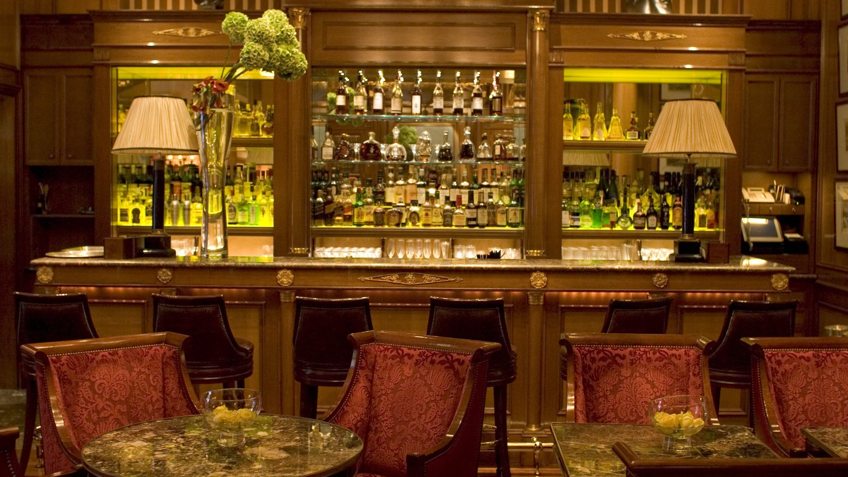 Le Bar, red chairs, marble tables and cocktail bar.