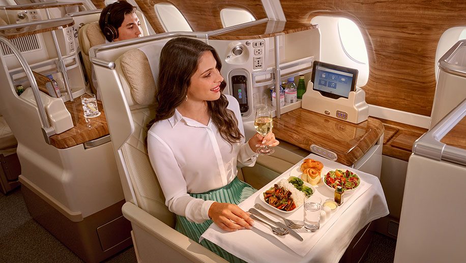 a woman drinking wine while eating food in emirates