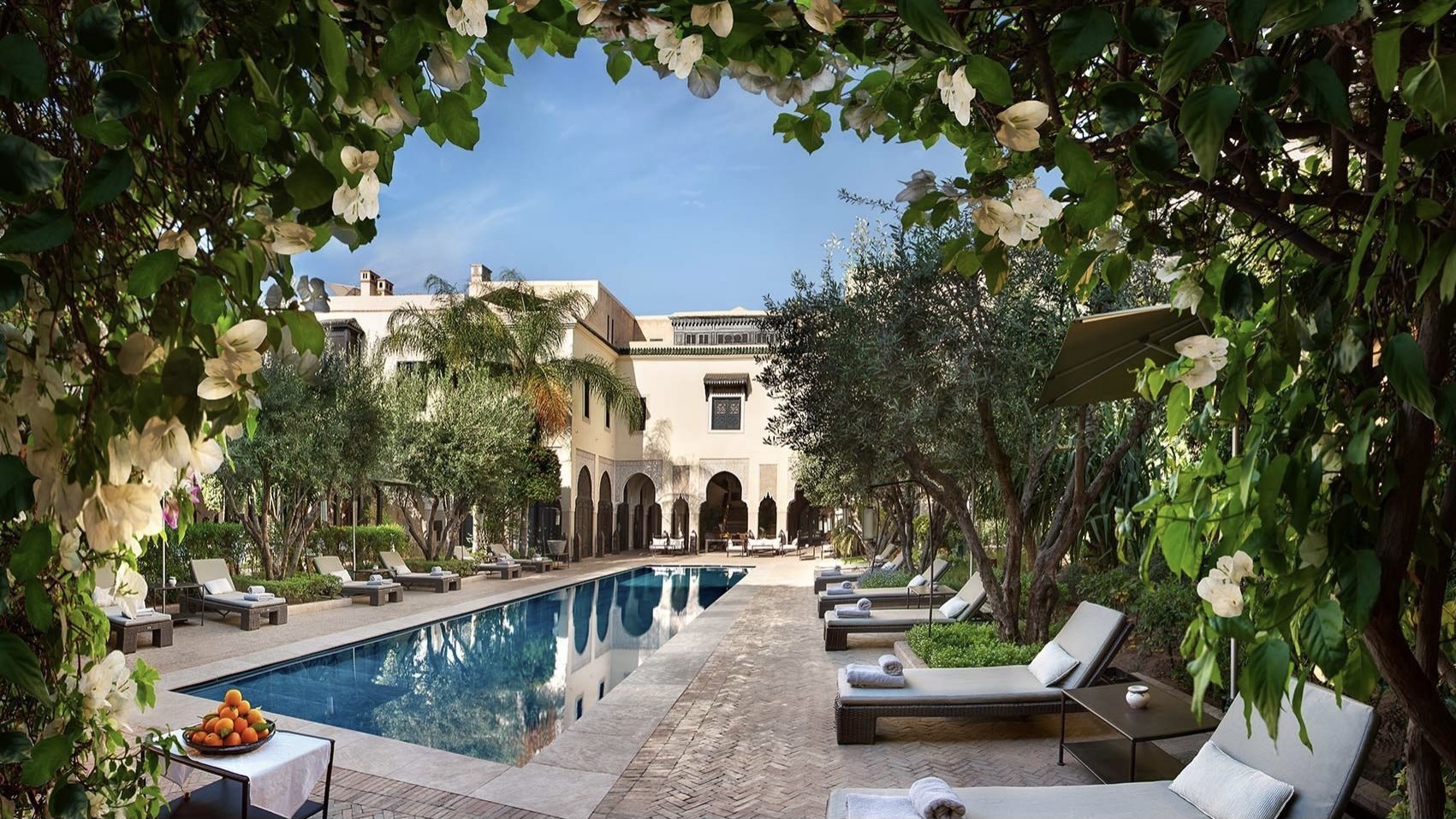 Long pool with sunbeds and trees in the swimming pool area at La Villa des Orangers