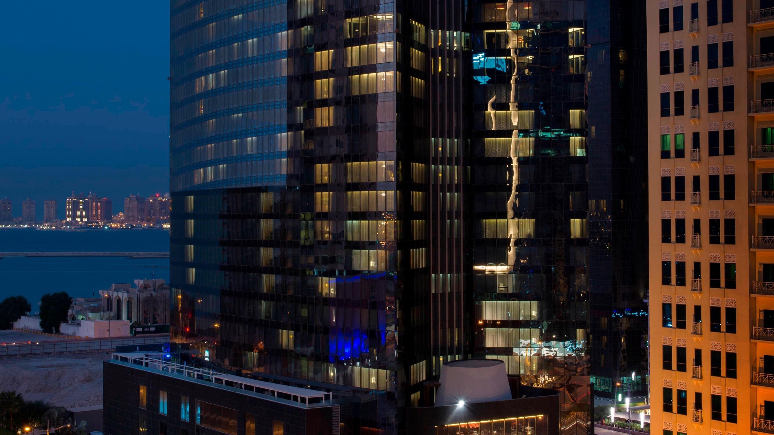 Outside view of Hotel W Doha, A large black and modern building.